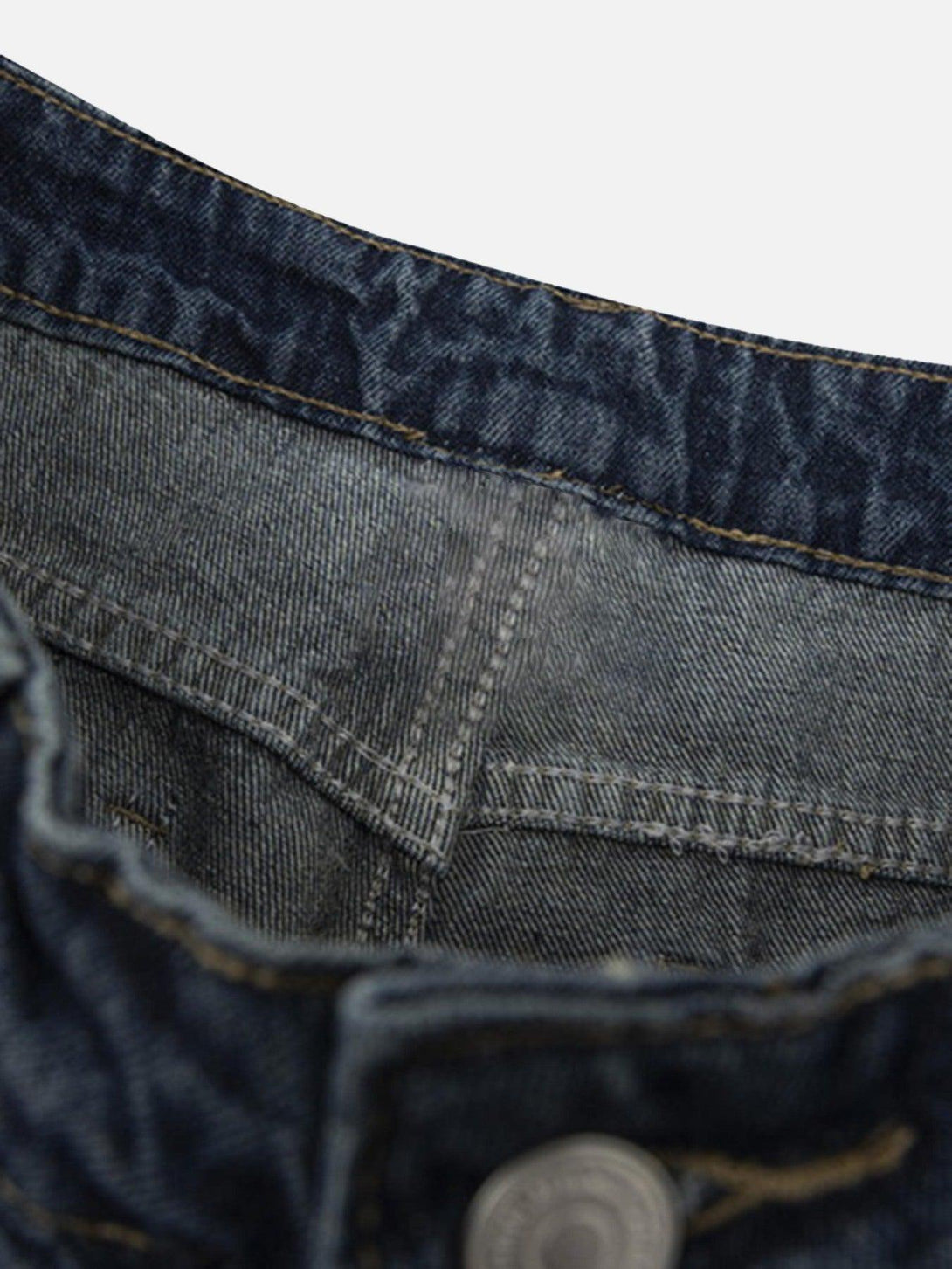 Intricate look at TALISHKO denim pants' waistband, showcasing vintage texture and stitching.