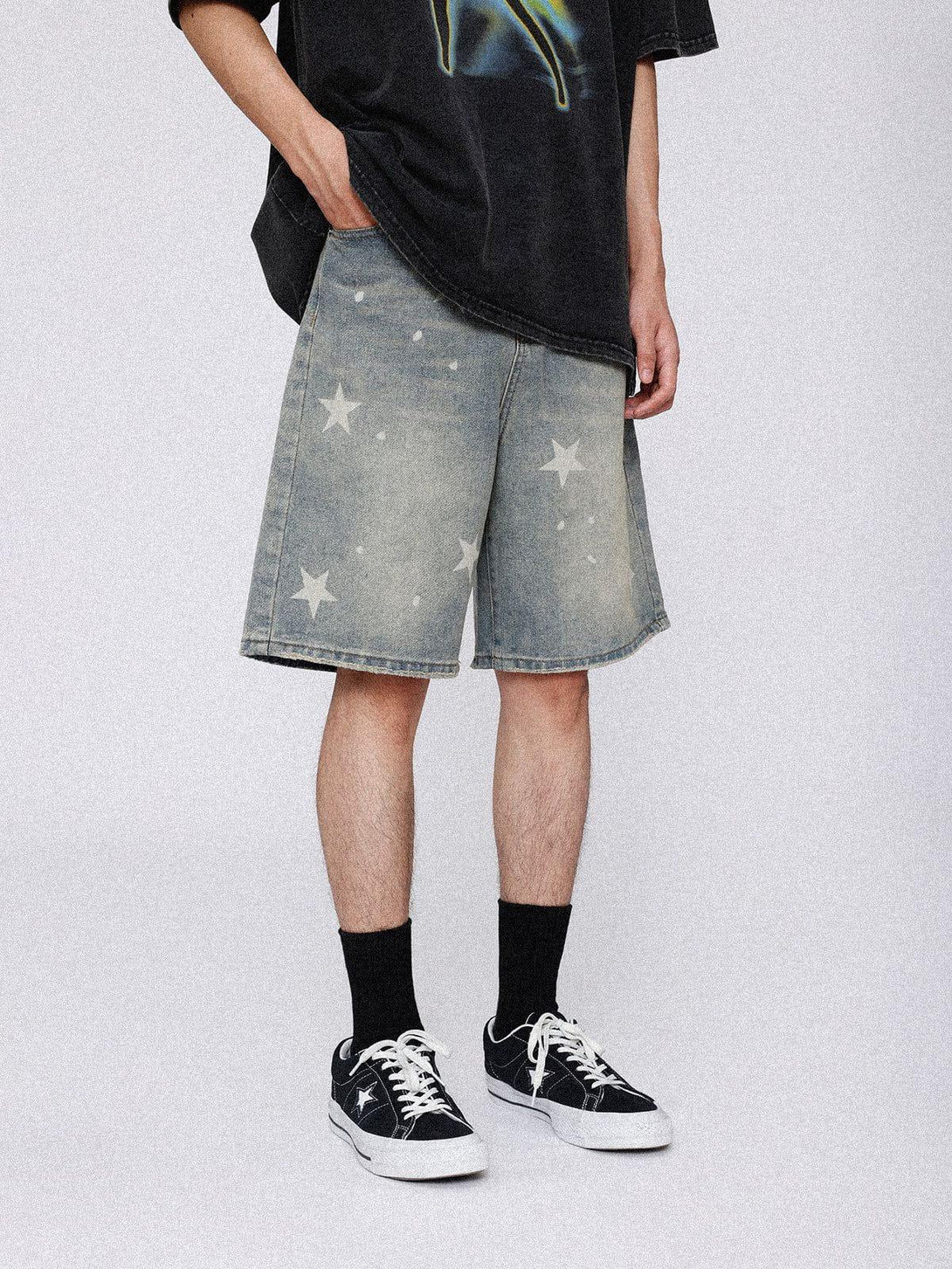 Model showcases TALISHKO vintage star jorts, styled casually with a black tee and sneakers.
