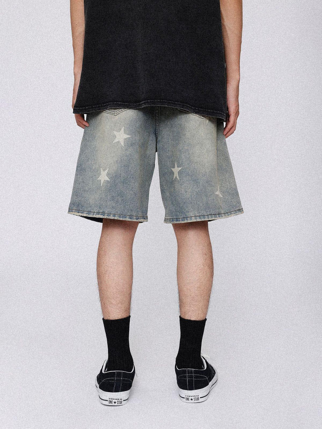 Back view of TALISHKO vintage star jorts, paired with a black tee and sneakers for casual flair.