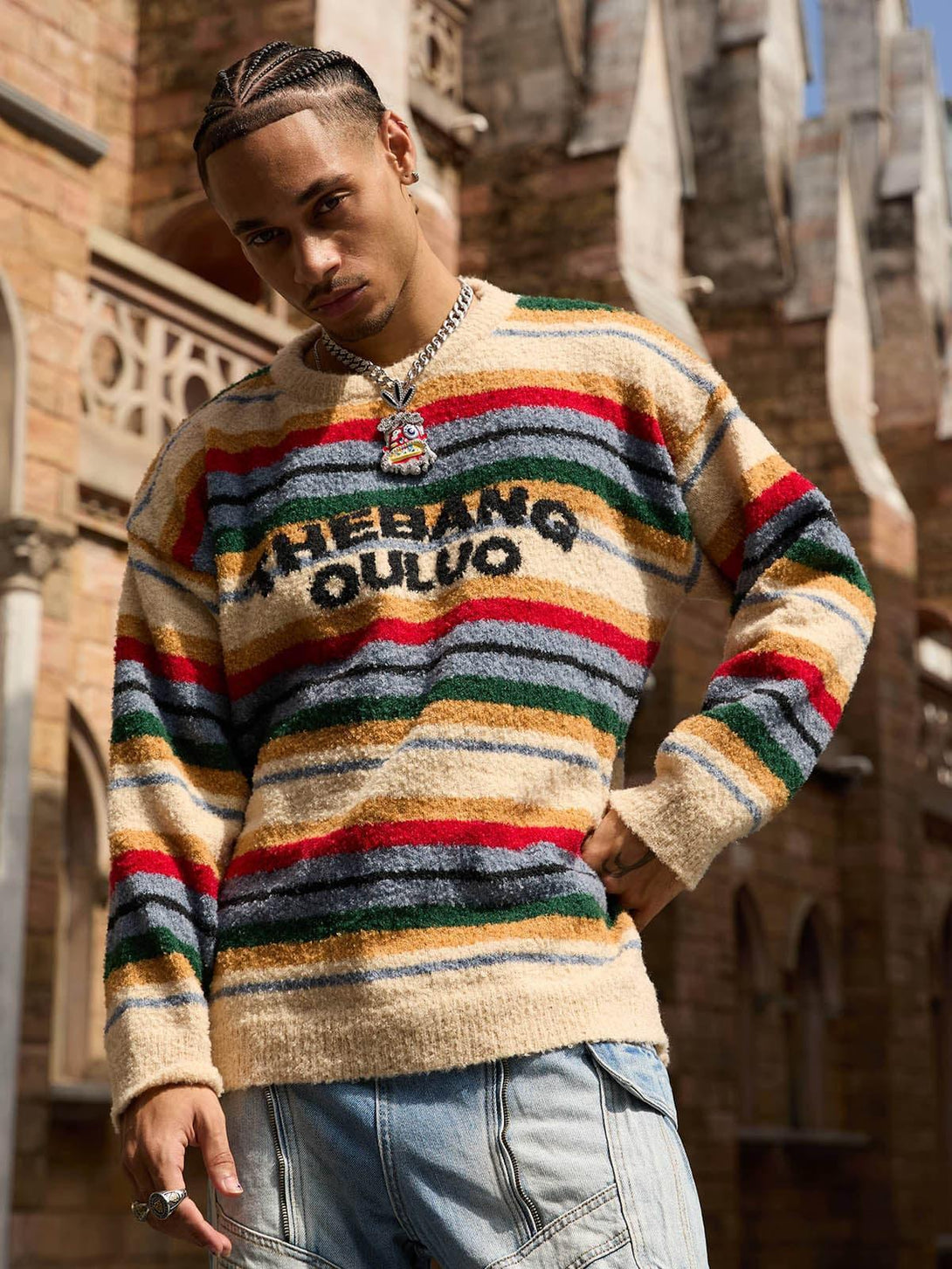 Model wearing a vintage striped sweater with bold lettering, captured in an urban setting by TALISHKO.