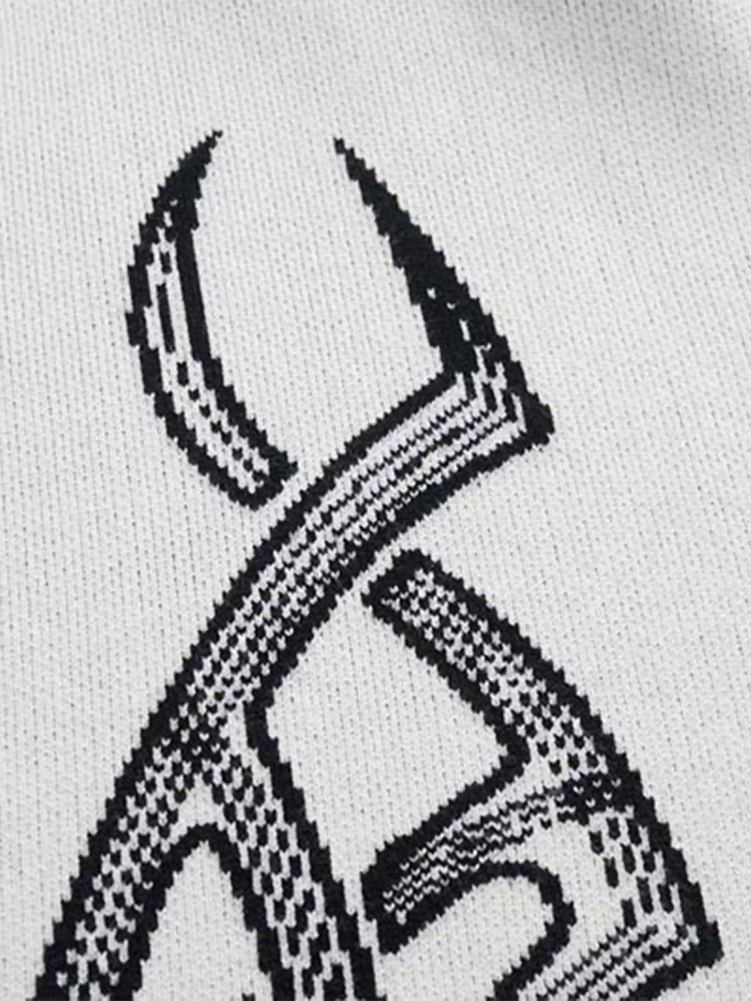 Intricate look at the thorn patterns on a white TALISHKO cardigan, highlighting unique design.