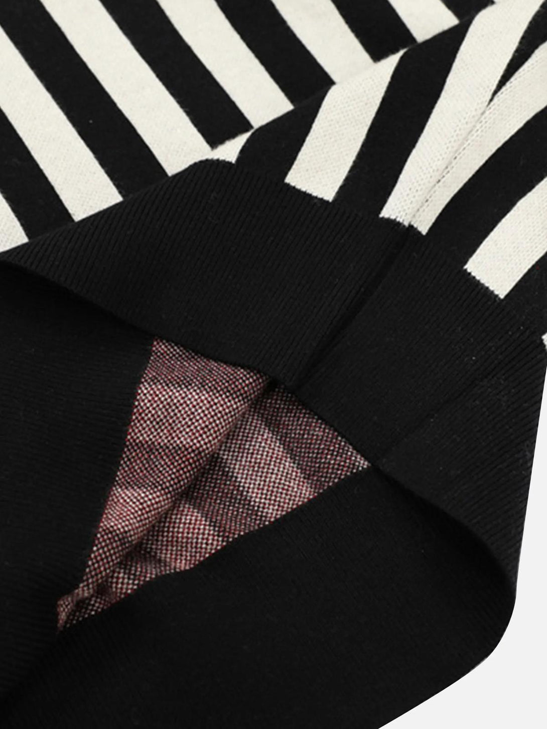 Detailed fabric and striped pattern of a vintage V-neck sweater by TALISHKO, showcasing preppy style.