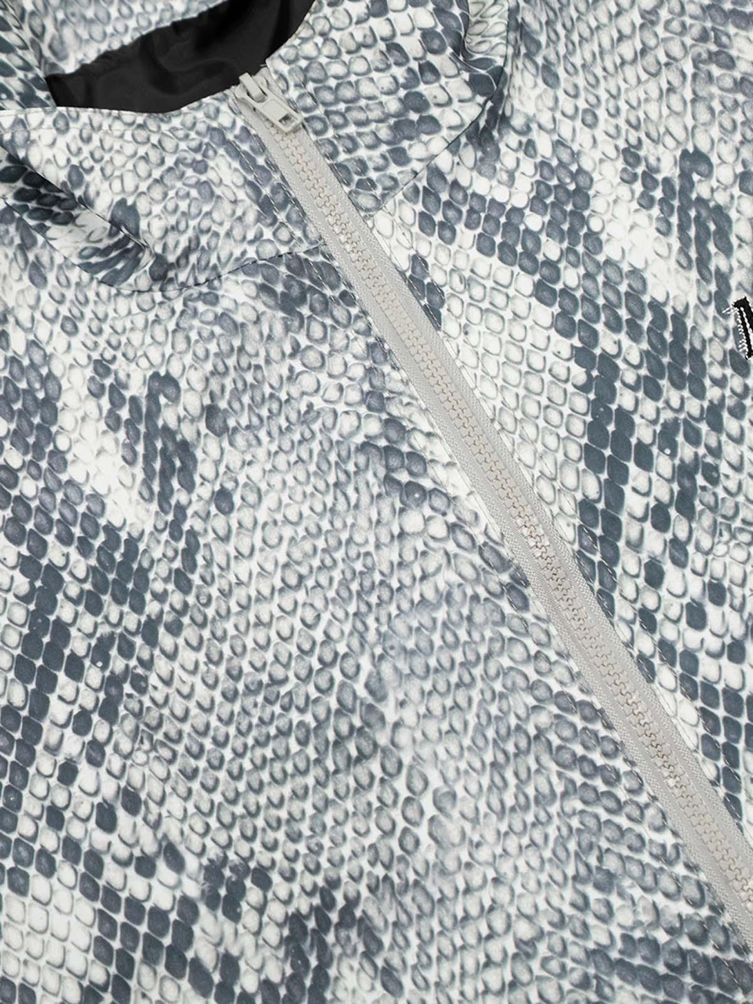 A close-up of the TALISHKO windbreaker jacket showcasing its gray snakeskin pattern.