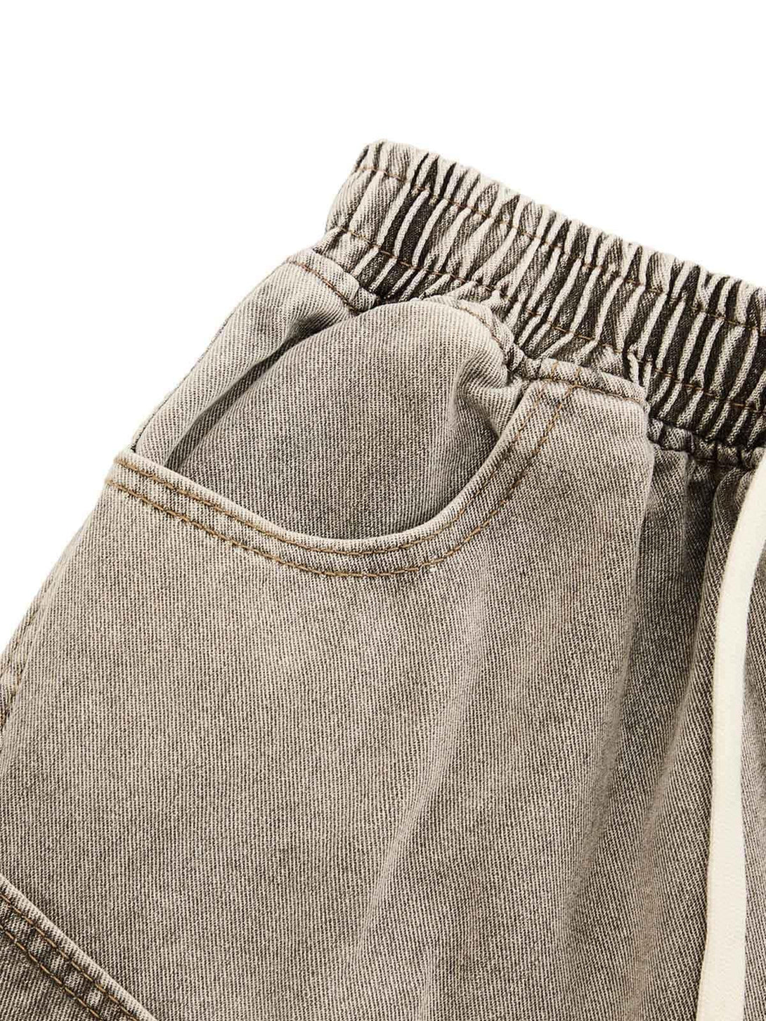 Detailed view of TALISHKO denim shorts showcasing elastic waistband and vintage wash texture.