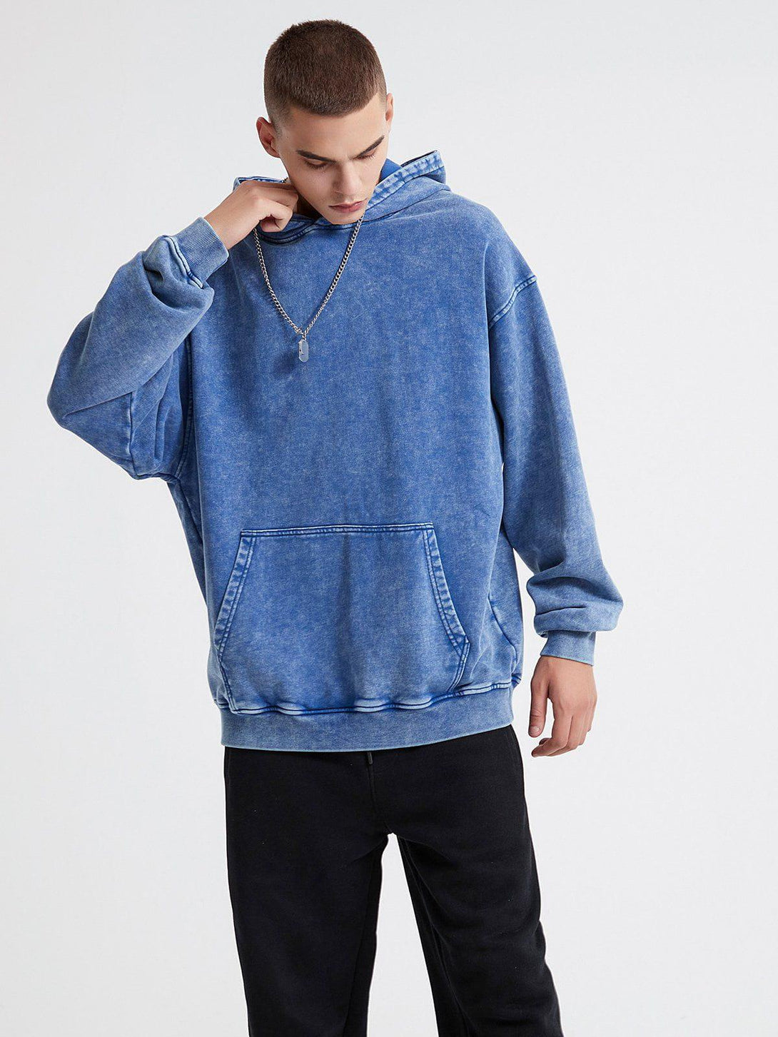 A model wearing a vintage wash distressed solid hoodie by TALISHKO, highlighting casual style.