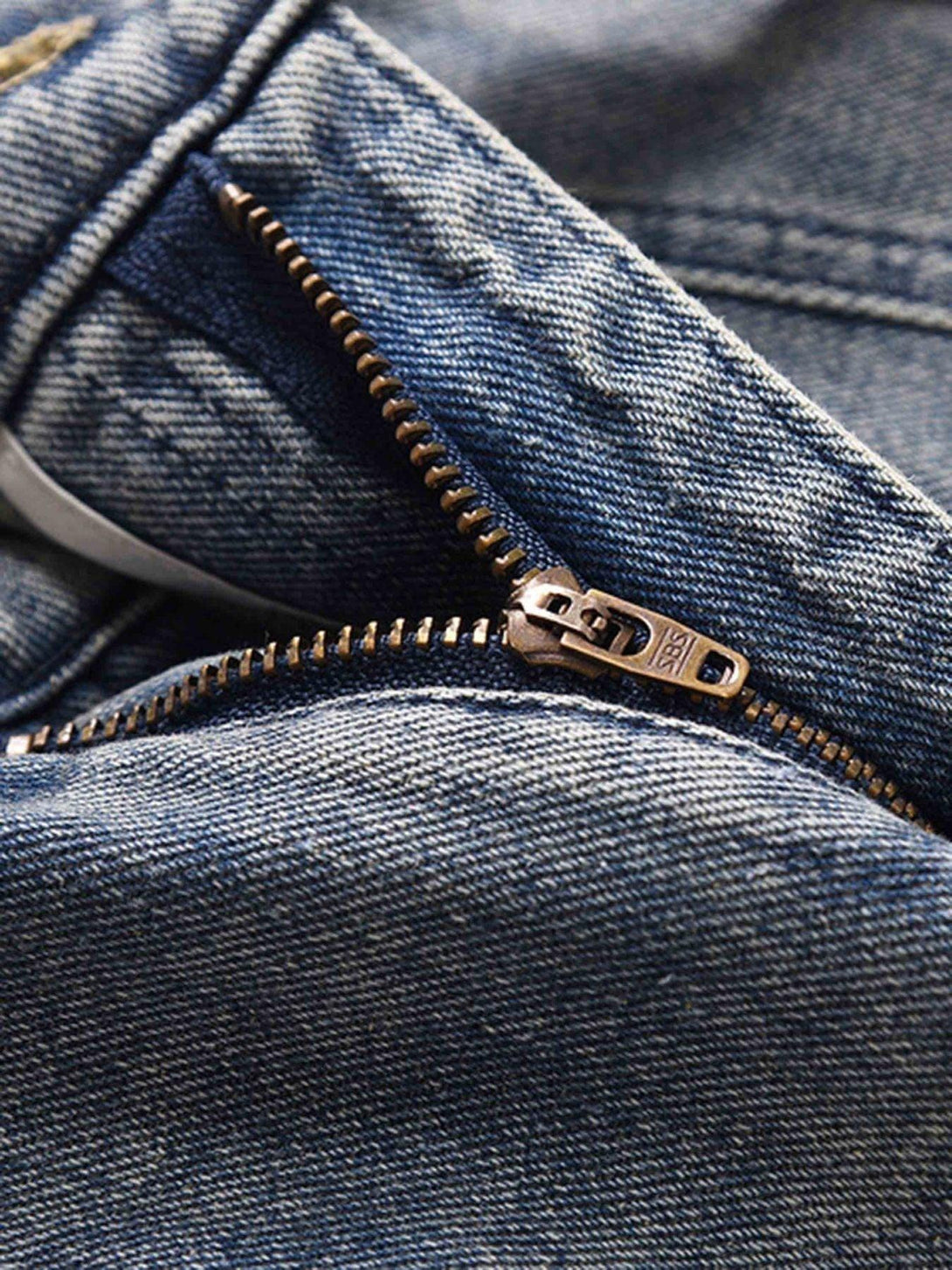 A close-up of TALISHKO's vintage washed jeans showcasing the sturdy zipper detail.