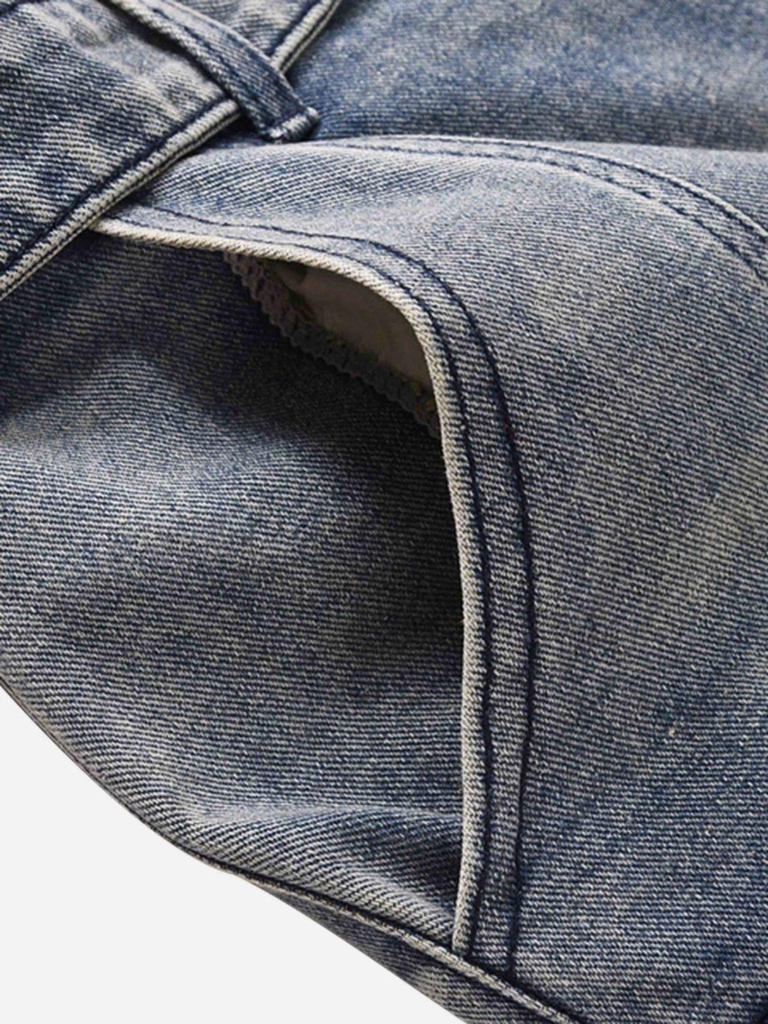 A tight crop highlighting TALISHKO's vintage washed jeans pocket and stitching details.