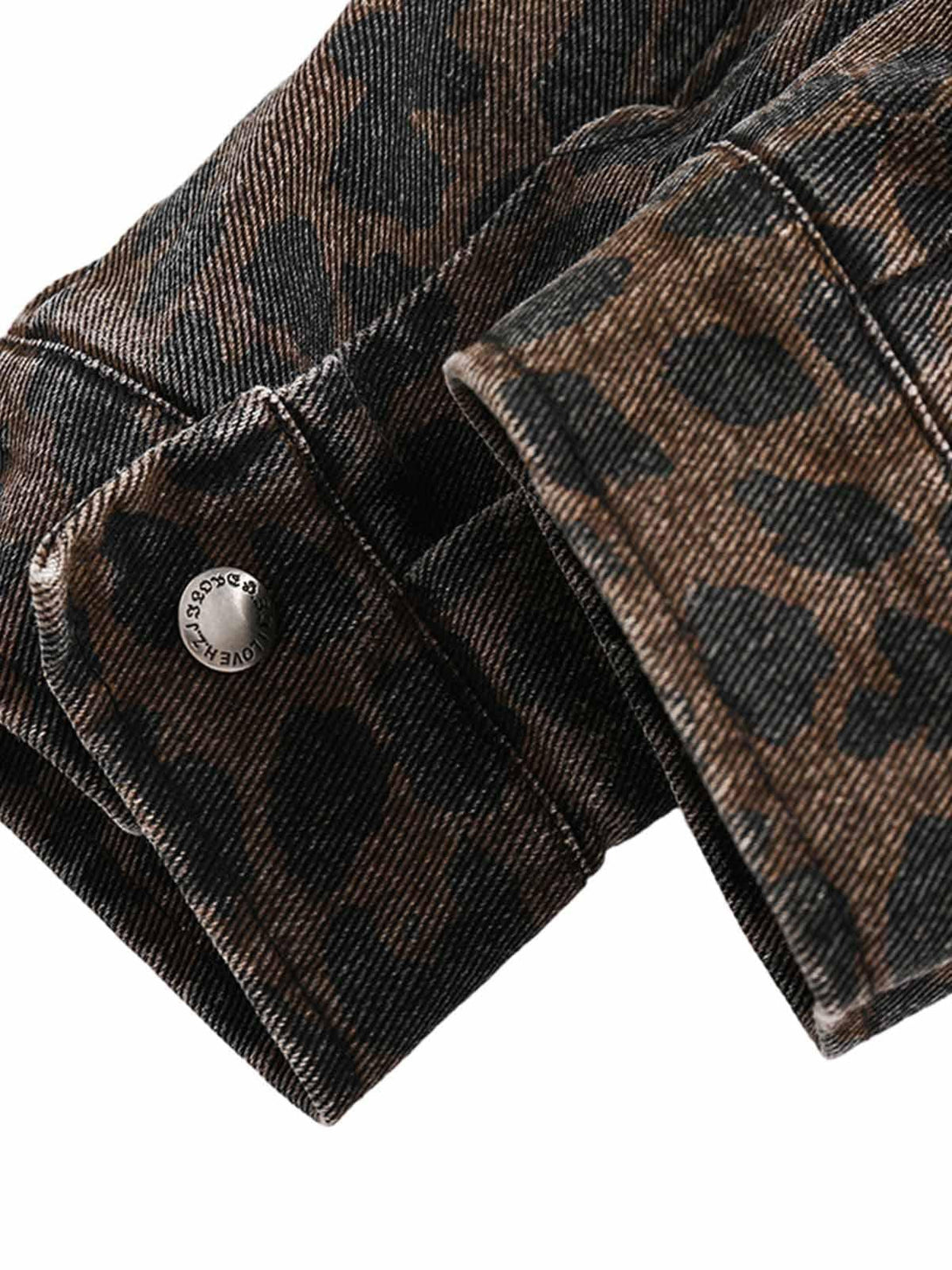 Intricate look at the sleeve design of a vintage washed cheetah denim jacket by TALISHKO.