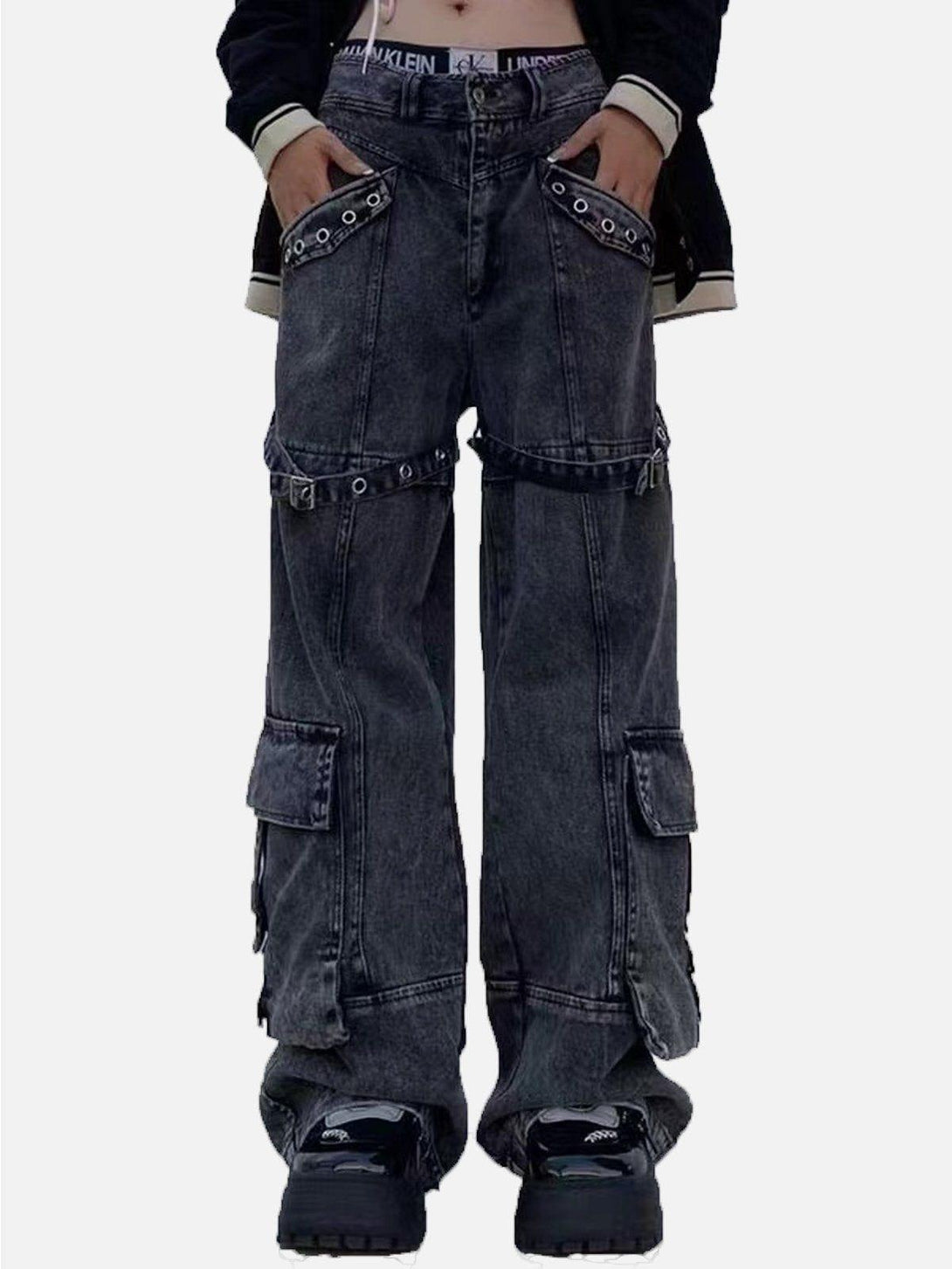 Model showcases TALISHKO vintage washed denim cargo jeans with eyelet accents and a relaxed fit.