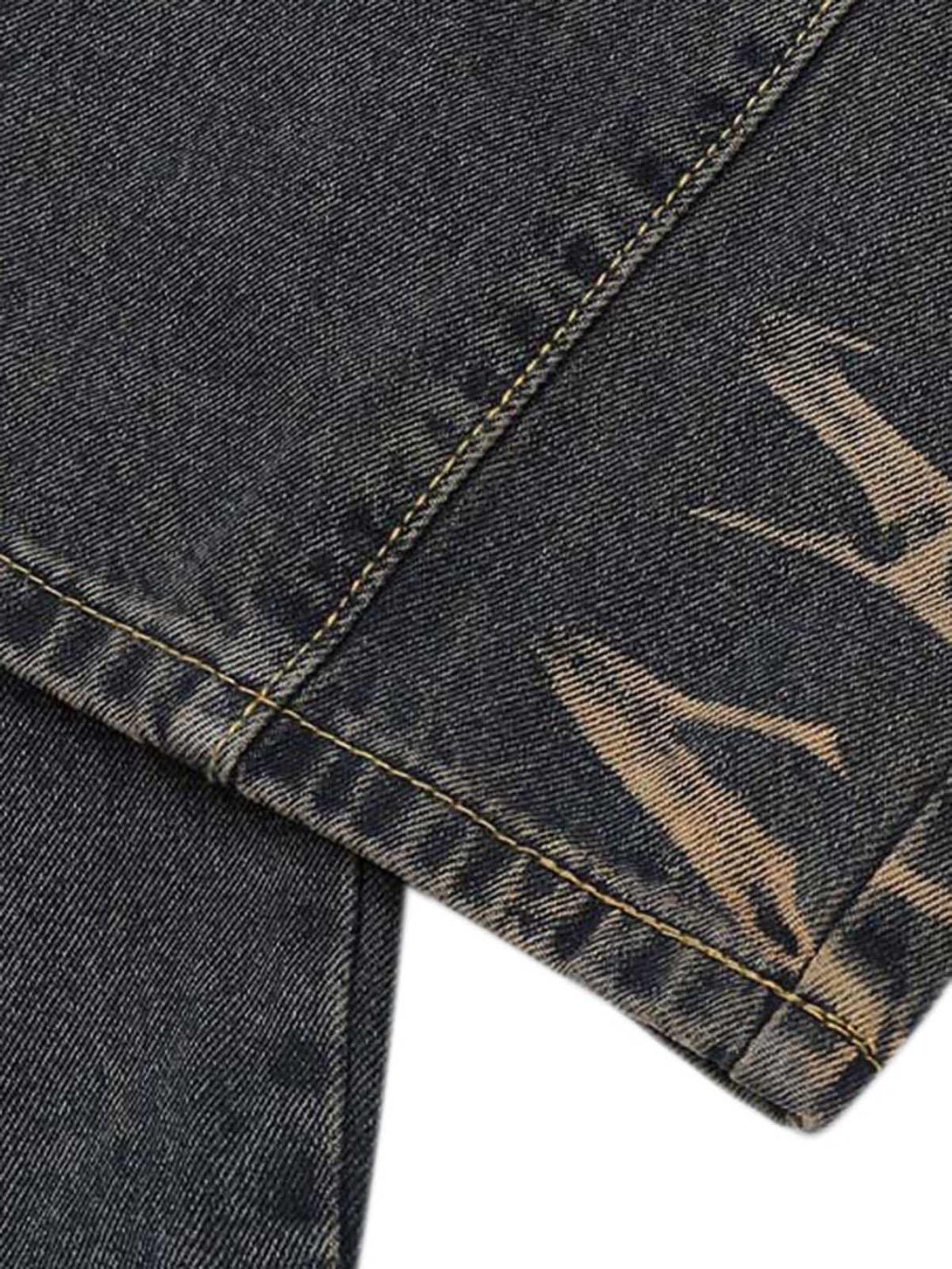 A detailed view of TALISHKO vintage washed cargo jeans highlighting distressed texture and stitching.