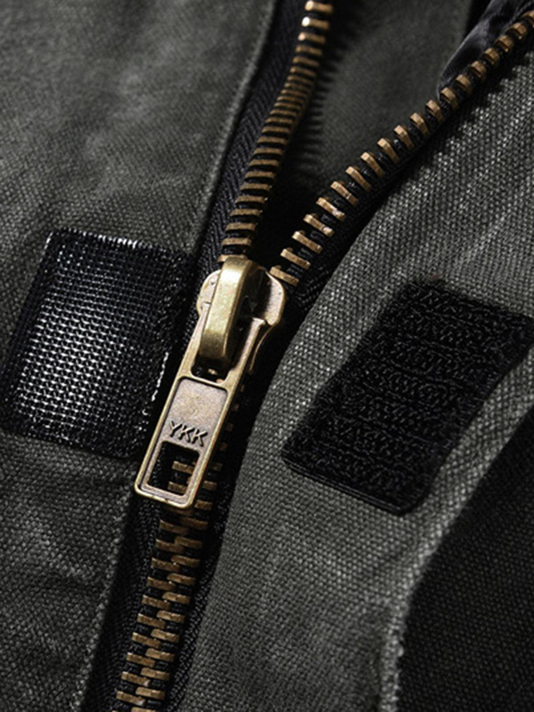Focusing on the zipper detail of TALISHKO's work jacket, highlighting its vintage aesthetic.