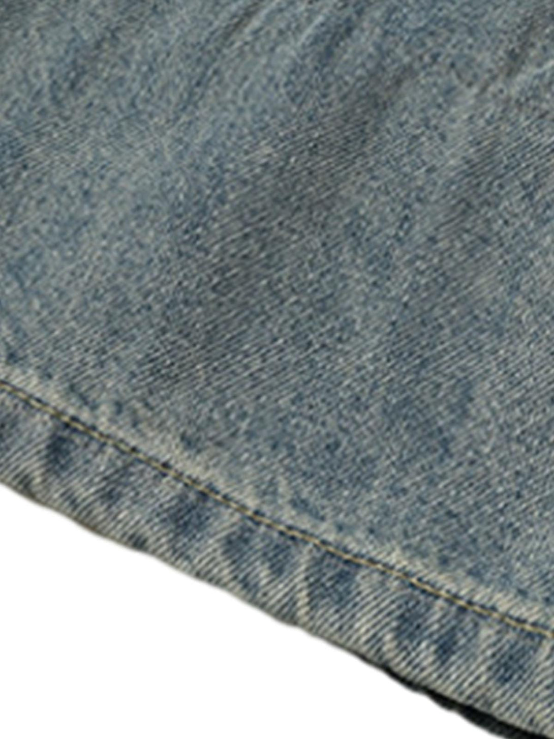 Focusing on the vintage washed denim texture of TALISHKO's baggy jeans, highlighting unique style.
