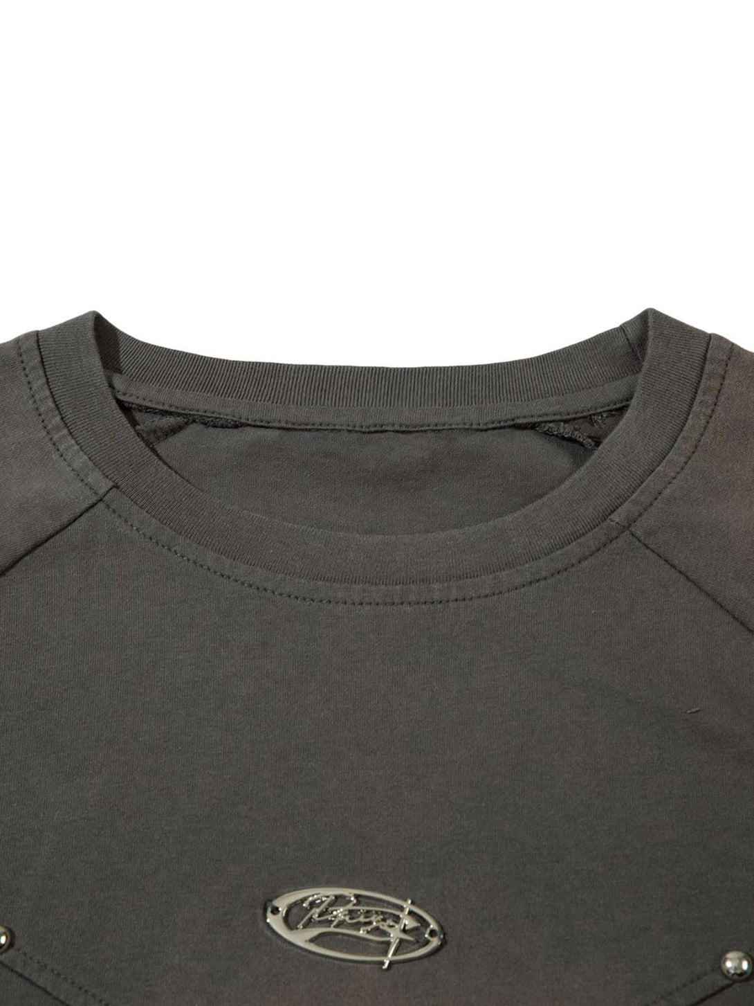 Close-up of gray T-shirt neckline with rivet detail and logo by TALISHKO, showcasing vintage flair.