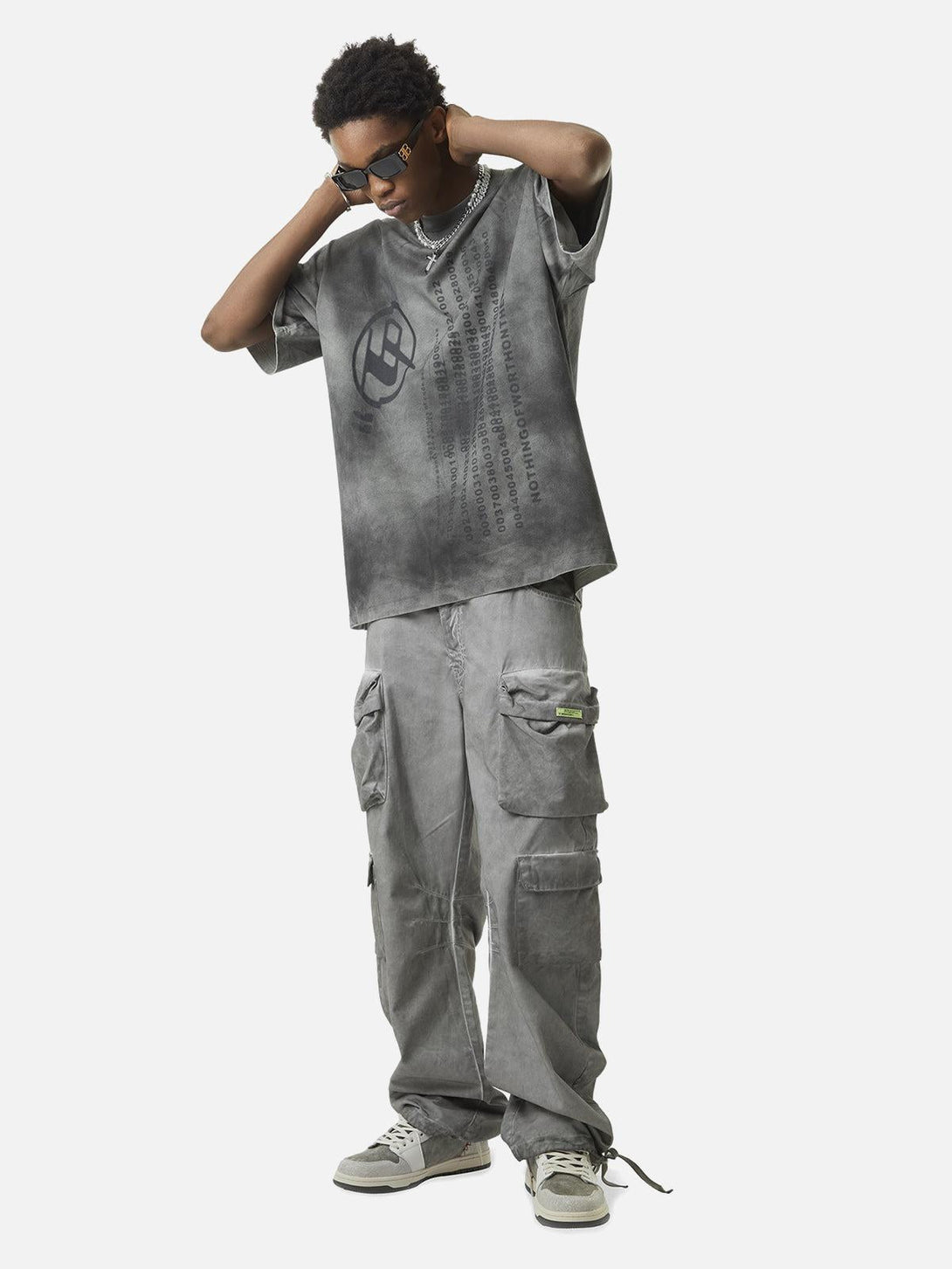 Model in TALISHKO vintage multi-pocket work pants and tee, showcasing an urban street style.