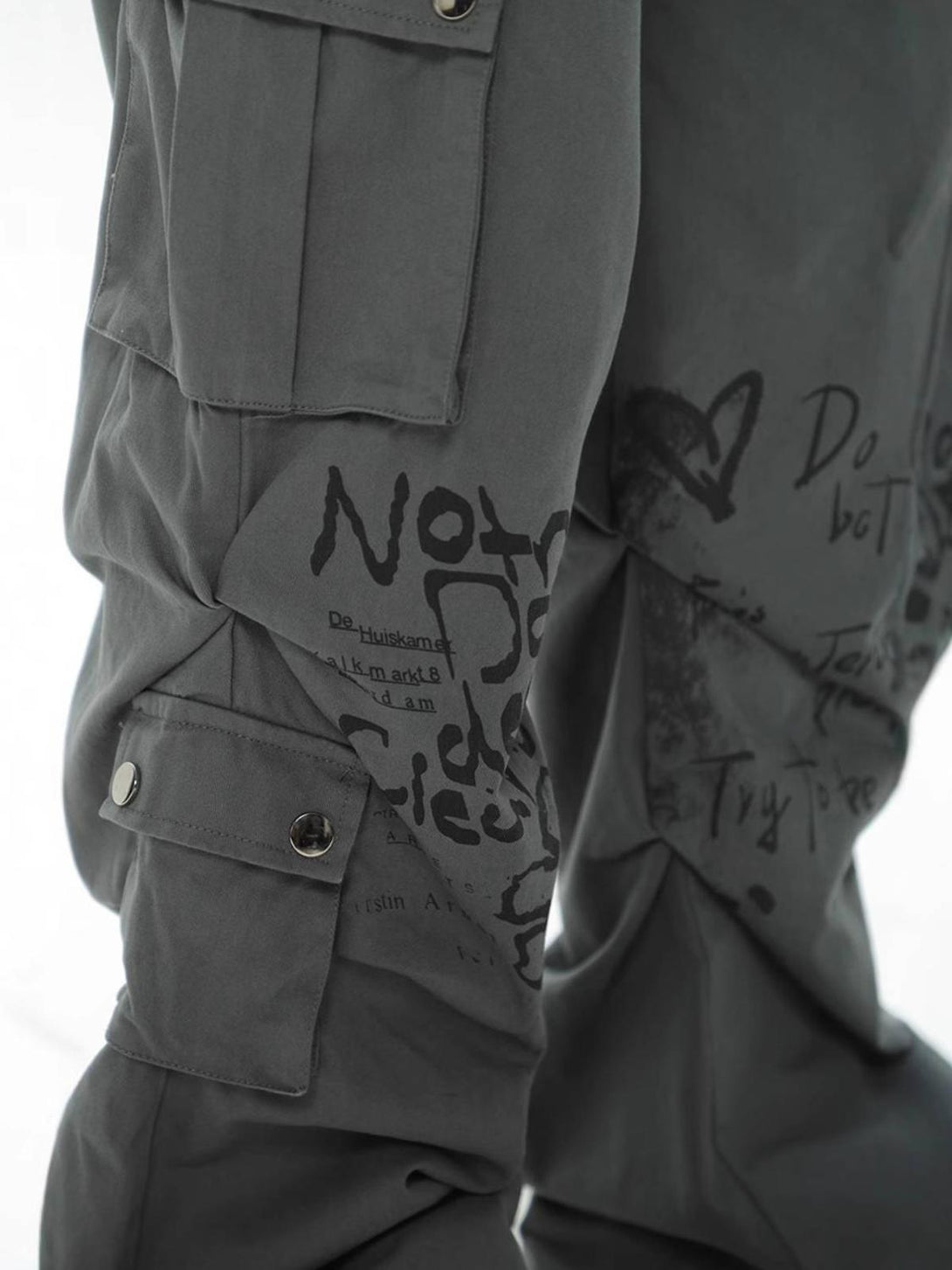 Detailed view of TALISHKO cargo pants with graphic prints, highlighting unique design elements.