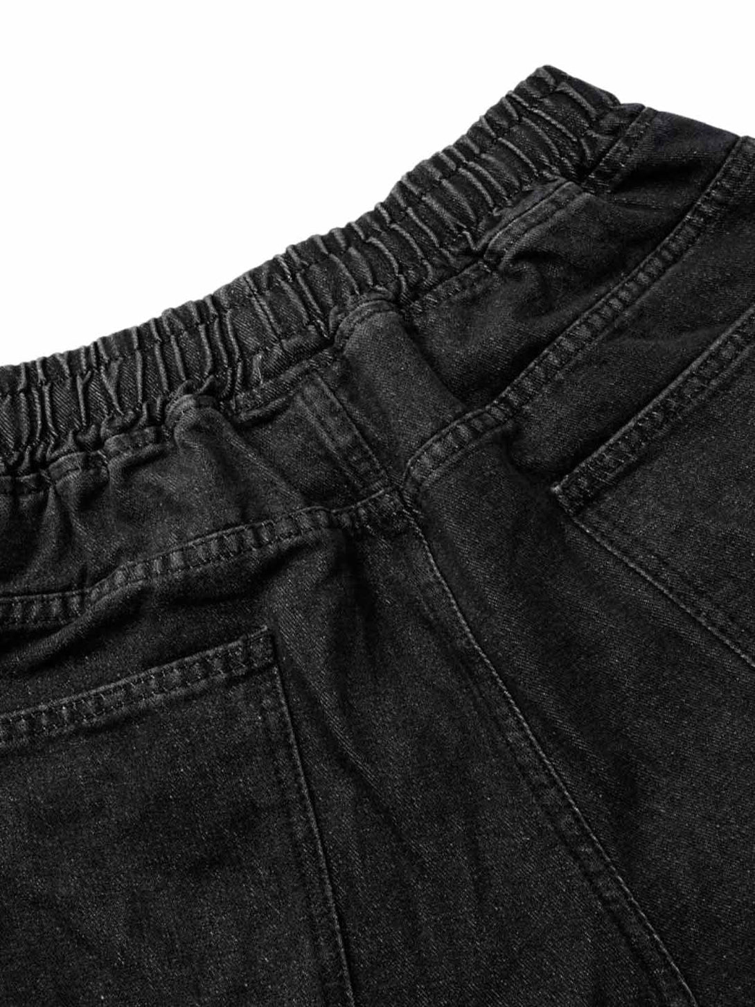 Focusing on TALISHKO's black washed cargo shorts, detailing the elastic waistband and pockets.