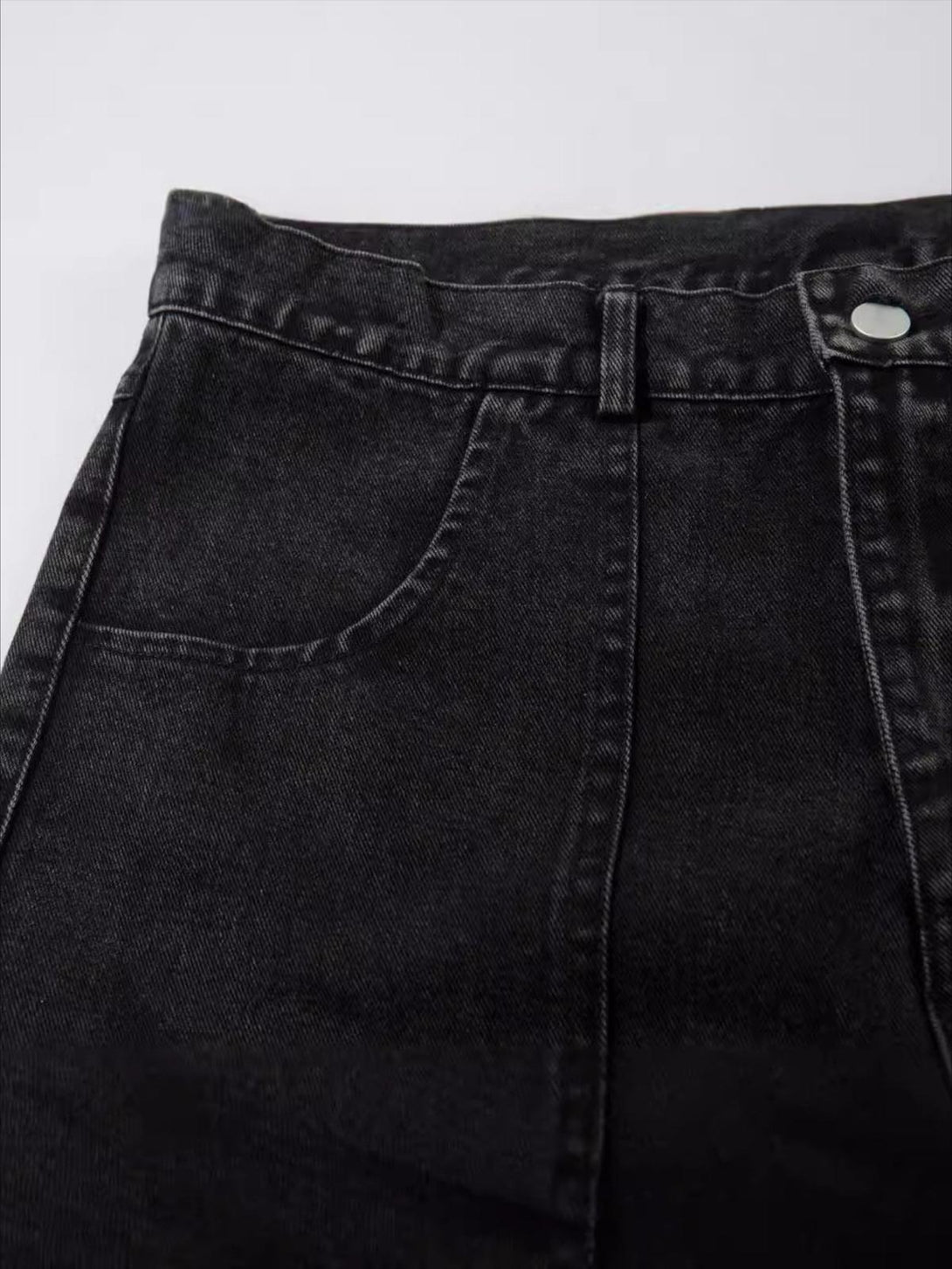 Intricate look at TALISHKO's washed cargo jeans, highlighting pocket and stitching details.