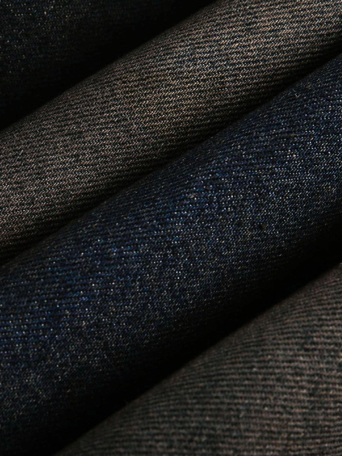 Zoomed-in texture of TALISHKO's washed denim fabric, highlighting intricate weave details.