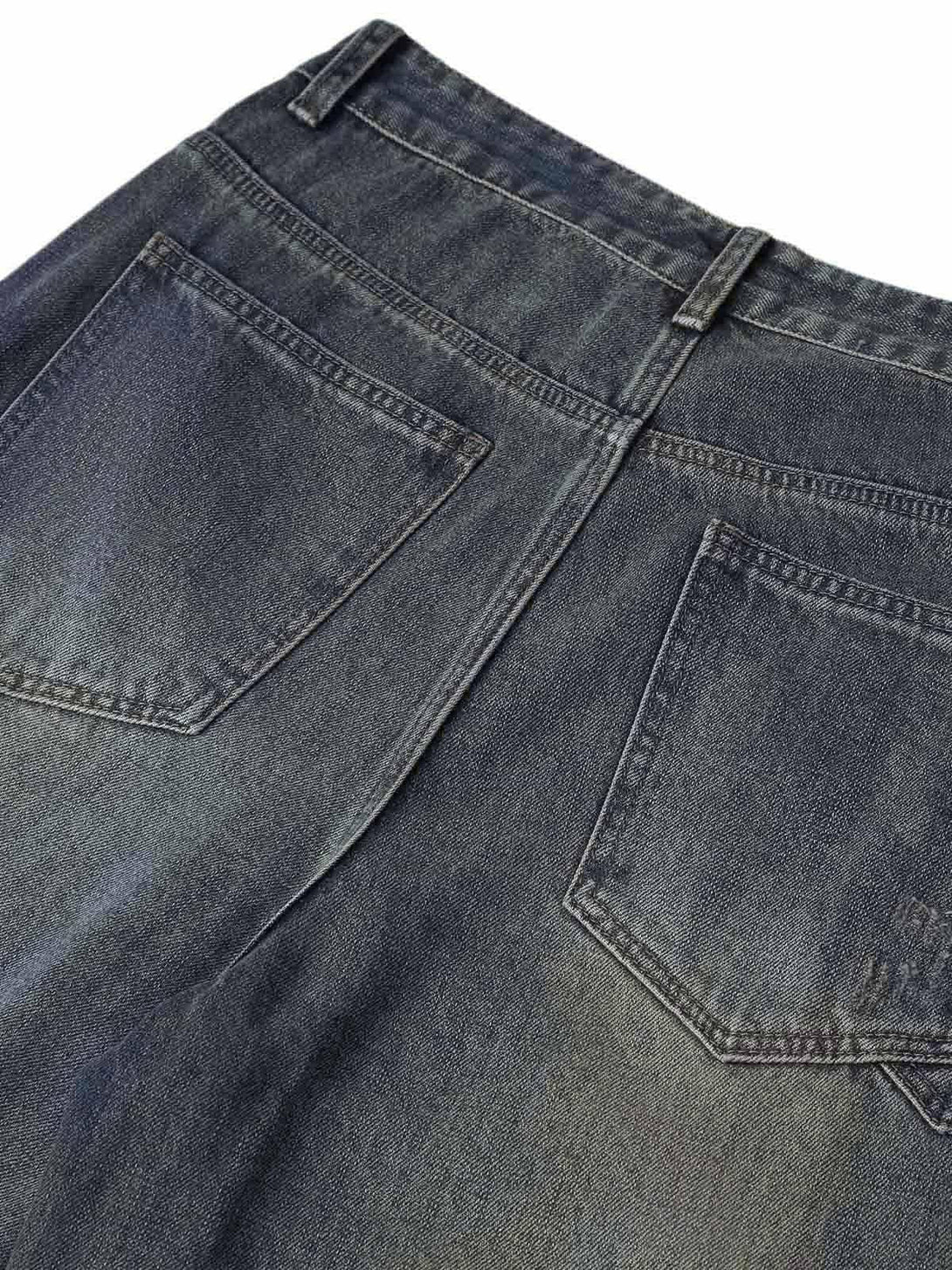 Detailed fabric and stitching on TALISHKO's washed dirty-dye straight jeans, showcasing the back pockets.