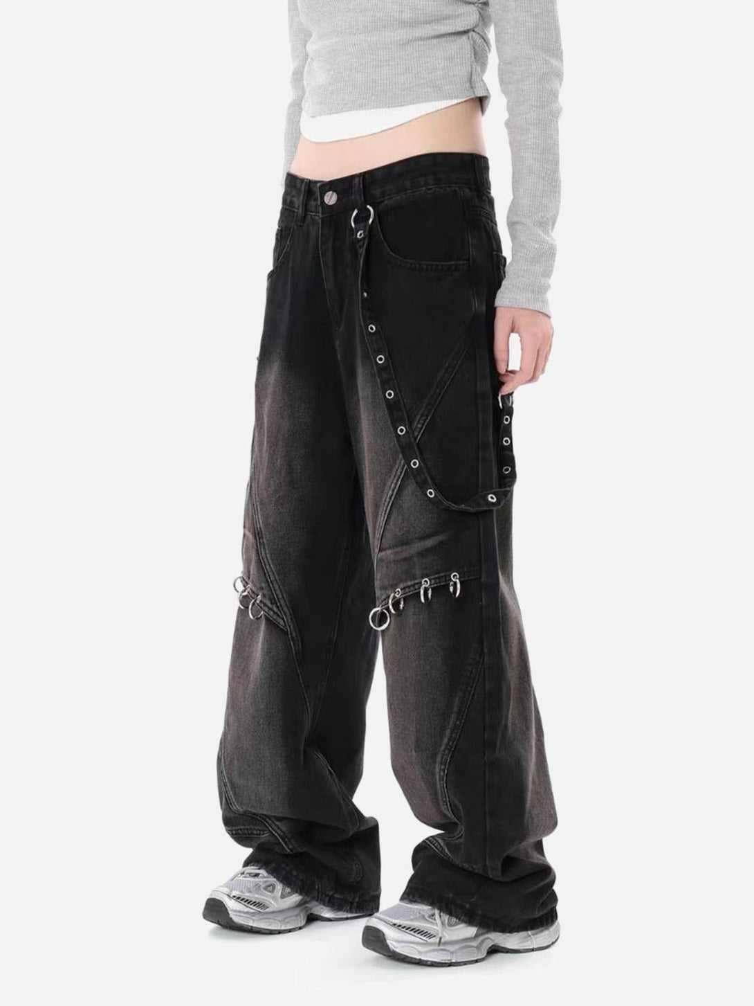 Model in TALISHKO washed distressed baggy jeans with metal accents, exuding a grunge vibe.