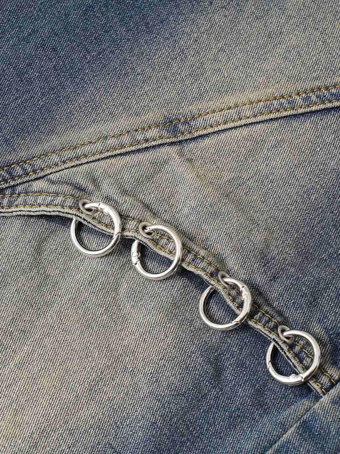 Intricate look at TALISHKO washed distressed baggy jeans, showcasing metal ring details.