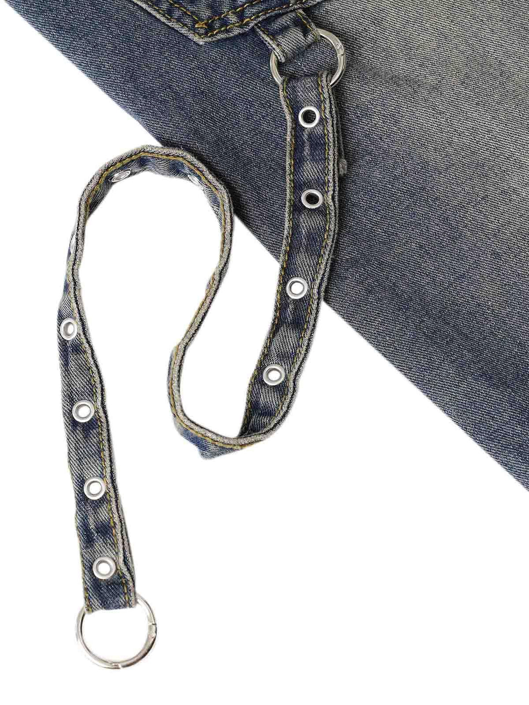 Detailed look at TALISHKO washed distressed baggy jeans, featuring metal ring and grommet accents.