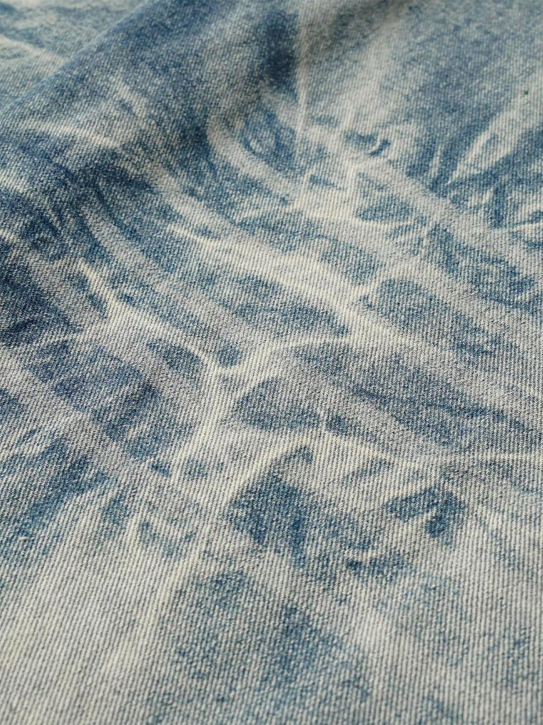 Zoomed-in texture of TALISHKO's washed distressed jeans, highlighting the unique fabric pattern.