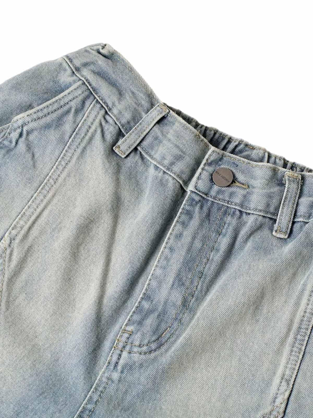 Detailed fabric and stitching of TALISHKO washed denim shorts, highlighting relaxed style.