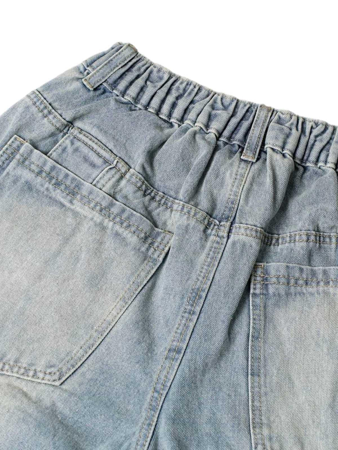 A detailed look at TALISHKO's elastic waistband and pocket design on washed denim shorts.