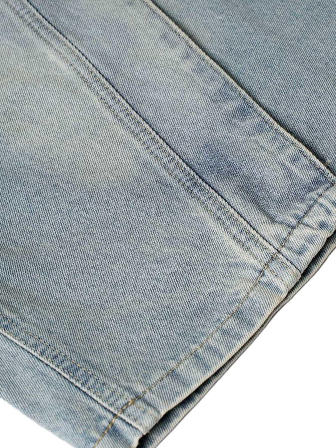A tight crop highlighting TALISHKO's washed denim fabric and intricate stitching details.