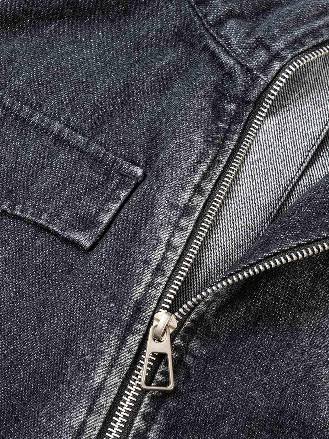 Intricate look at TALISHKO's washed distressed denim jacket, showcasing zipper and fabric texture.