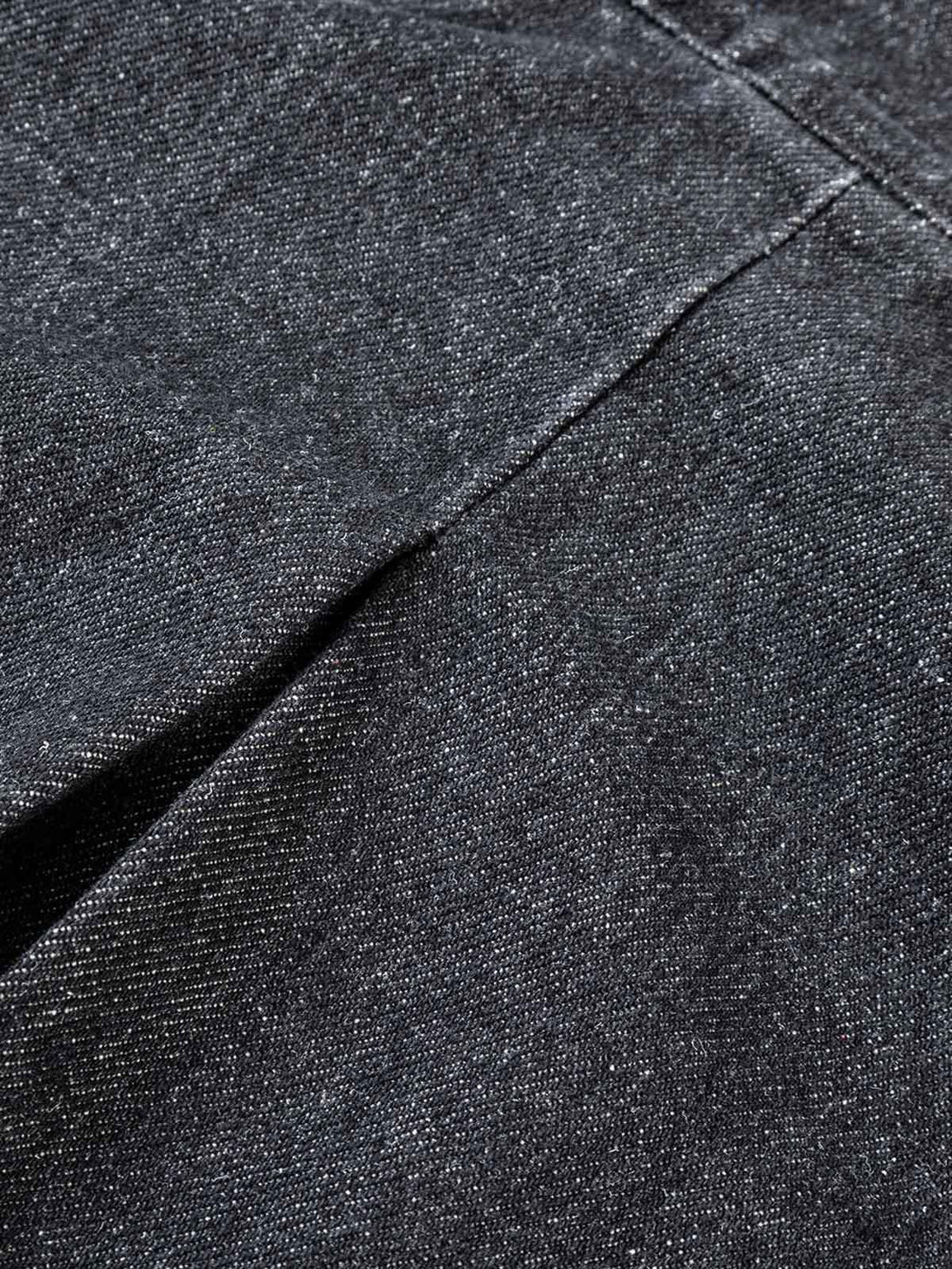 Zoomed-in texture of TALISHKO's washed distressed denim jacket, showcasing fabric details.