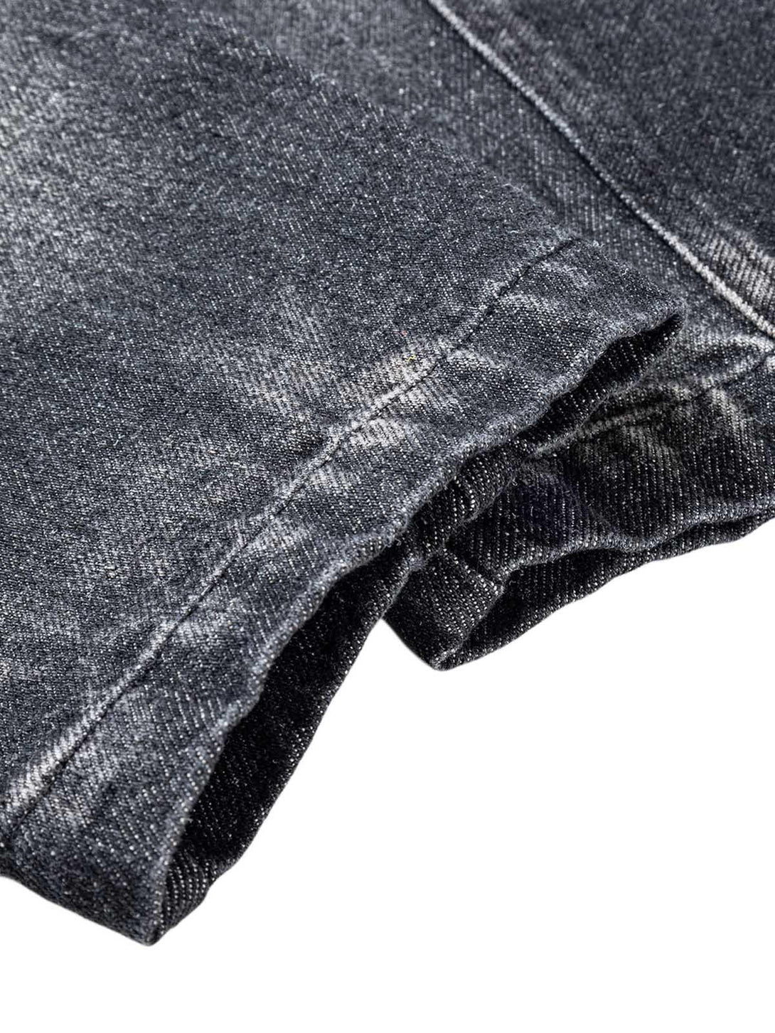 Detailed fabric and stitching of TALISHKO's washed distressed denim jacket, showcasing craftsmanship.