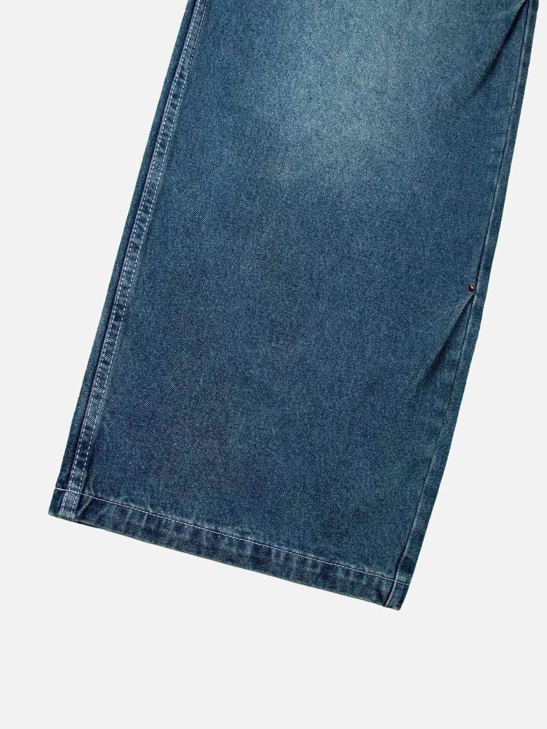 A detailed view of TALISHKO's washed distressed jeans, highlighting double pleat design.
