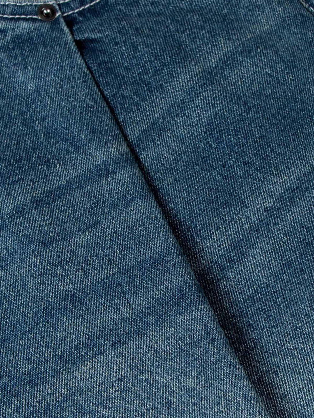 A tight crop highlighting the denim texture and double pleat detail of TALISHKO jeans.