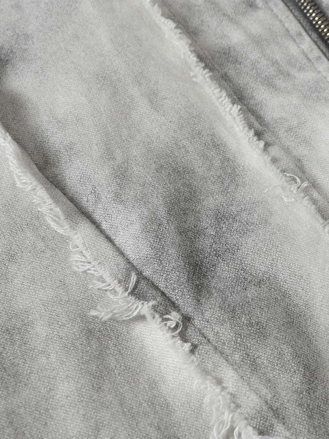 Zoomed-in texture of a washed distressed jacket by TALISHKO, highlighting unique fabric details.