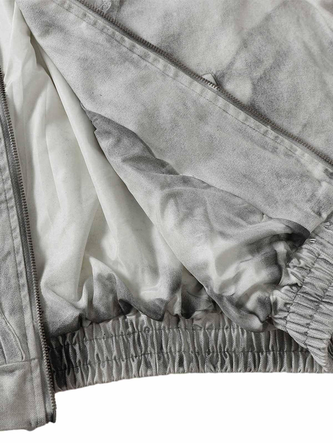 Detailed fabric and stitching of a washed distressed jacket by TALISHKO, highlighting its texture.