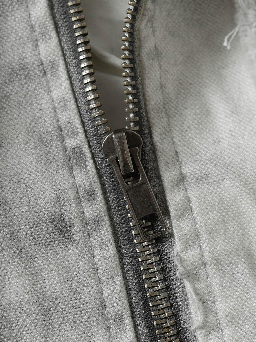 Intricate look at the zipper detail on a washed distressed jacket by TALISHKO.