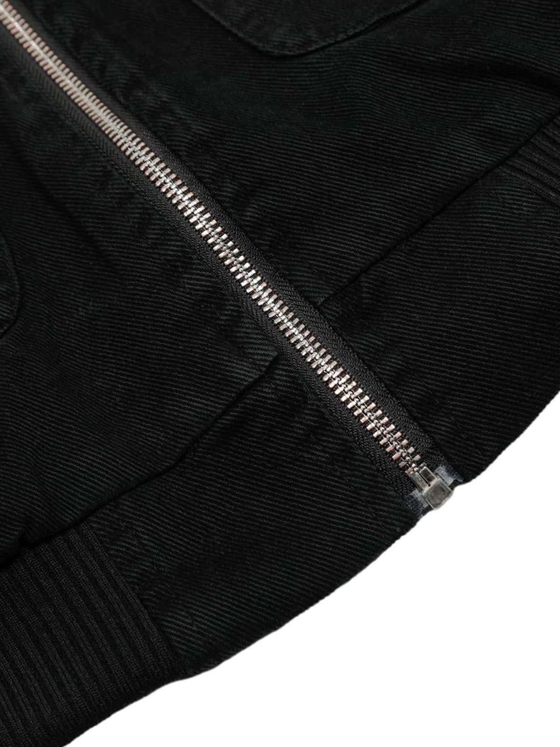 Intricate look at TALISHKO's jacket, highlighting the zipper and textured black fabric.