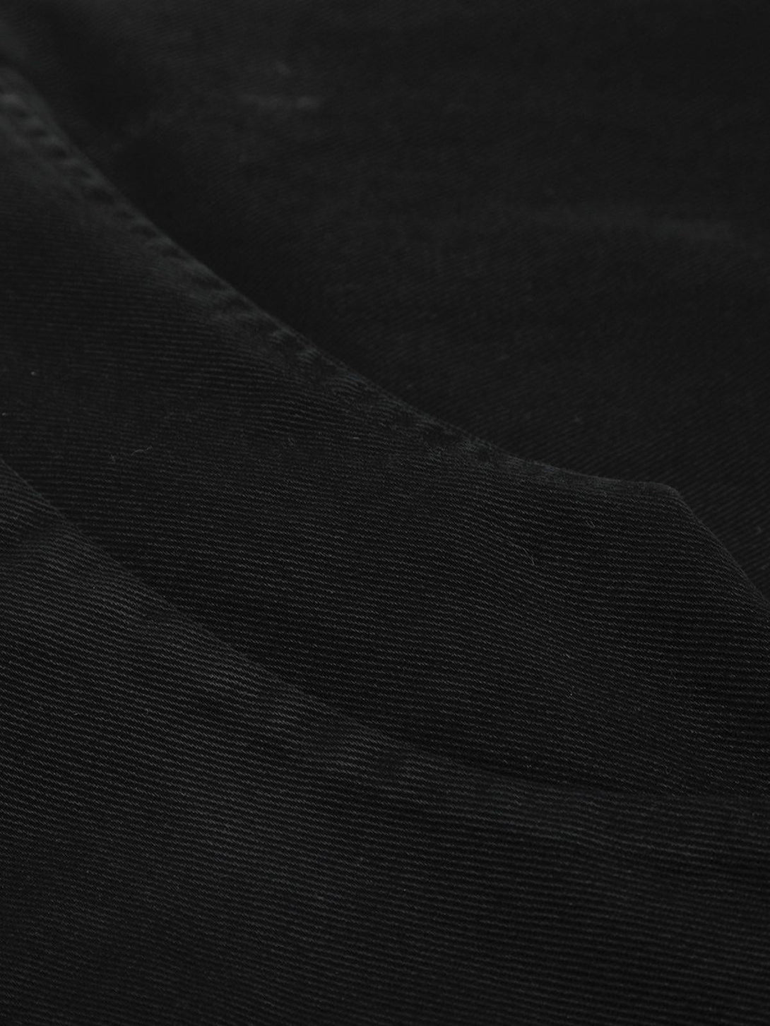 Detailed fabric and texture of TALISHKO's black jacket, showcasing its refined design.