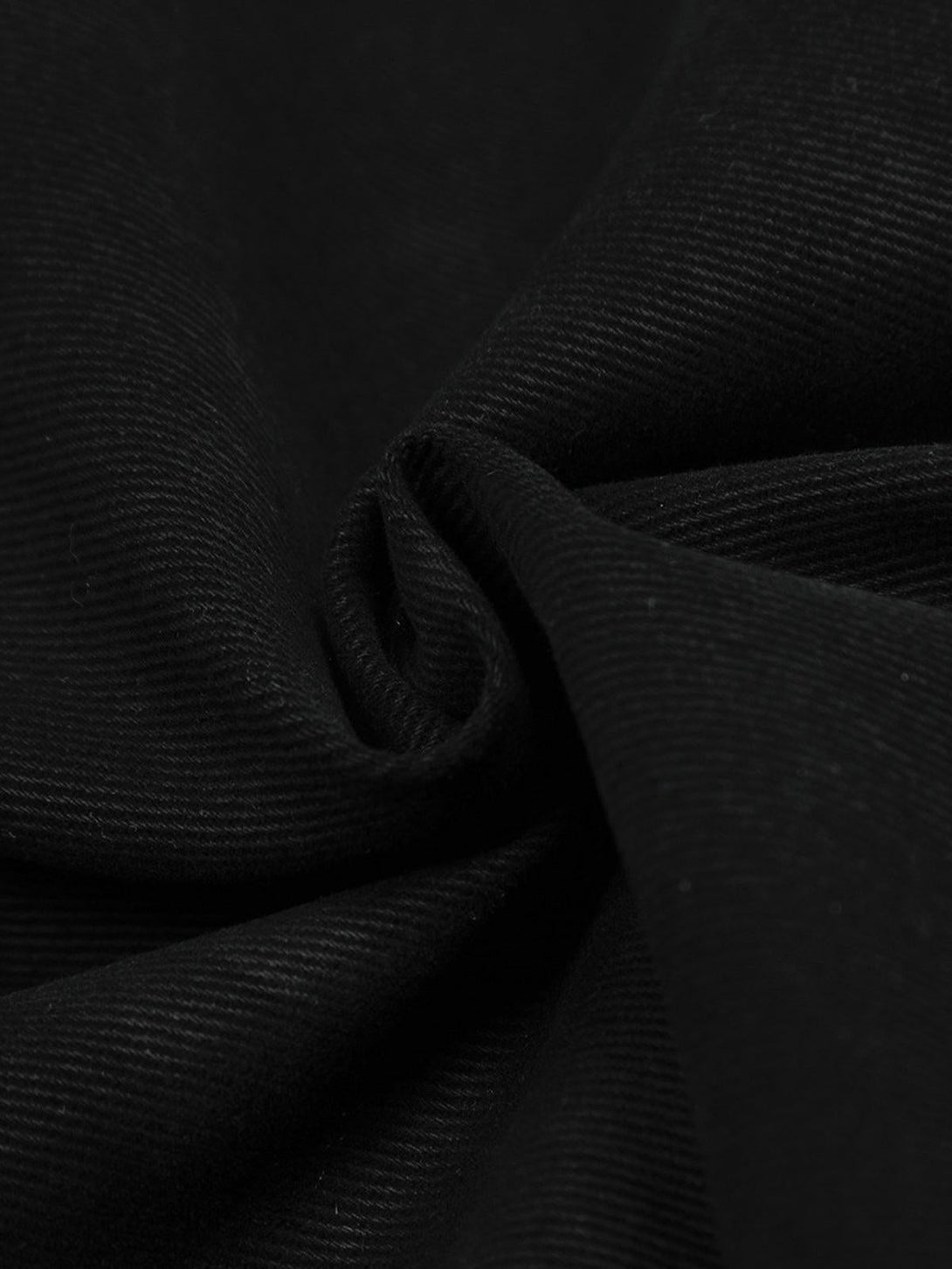 A tight crop highlighting the rich texture of TALISHKO's black jacket fabric.