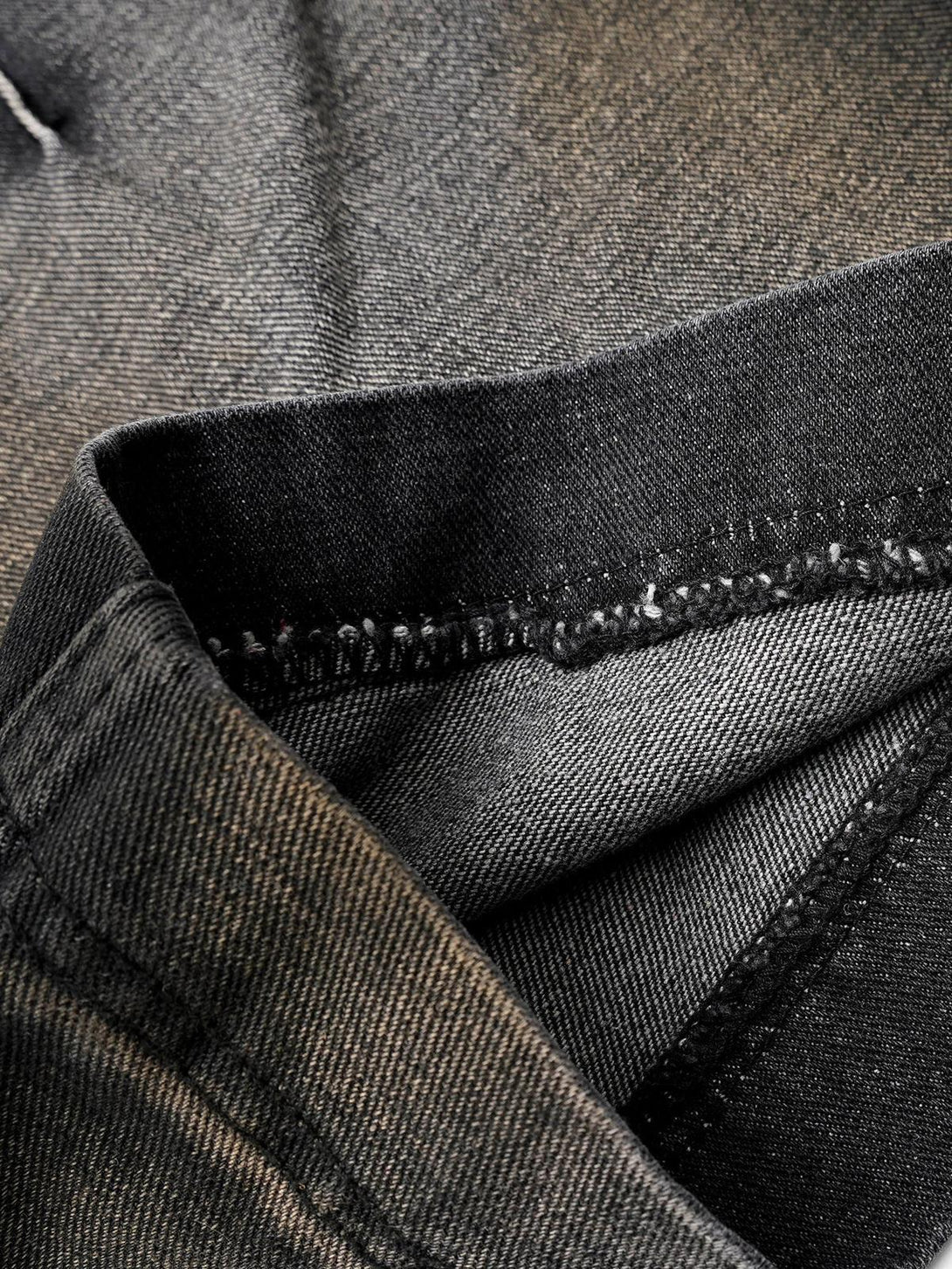 Intricate look at TALISHKO's washed distressed cargo jeans, showcasing fabric texture and stitching.