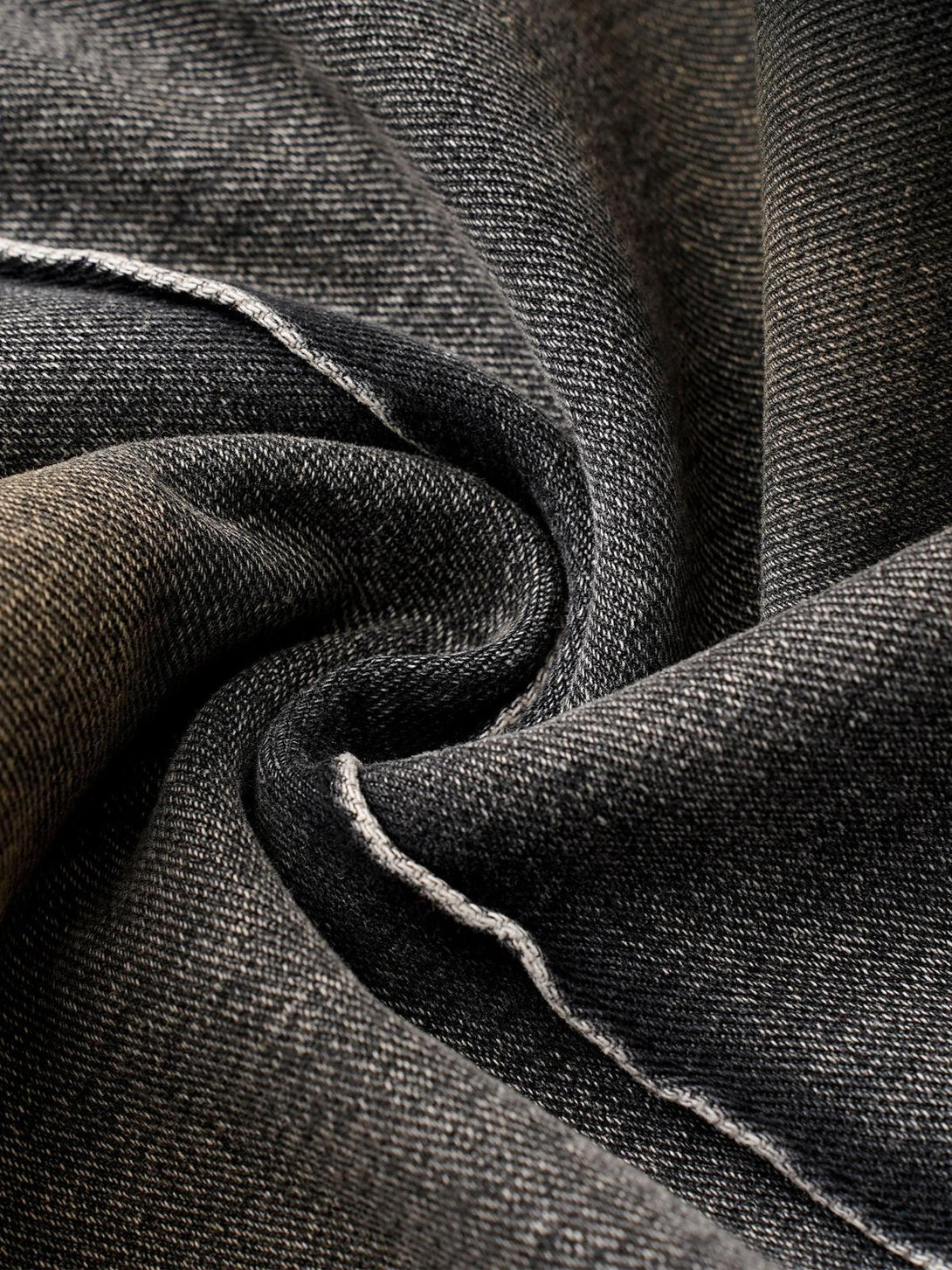 Intricate look at TALISHKO's washed distressed pleated cargo jeans fabric and stitching.