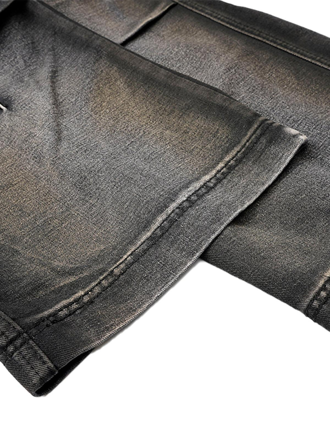 Detailed view of TALISHKO's washed distressed cargo jeans, highlighting texture and stitching.