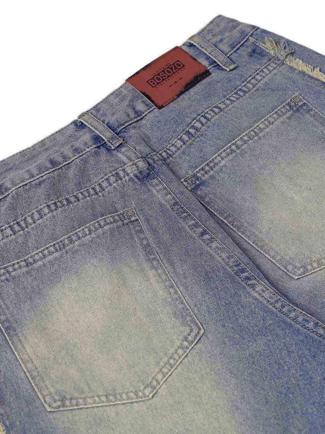 Back view of TALISHKO baggy jeans showcasing washed, distressed texture and raw edges.