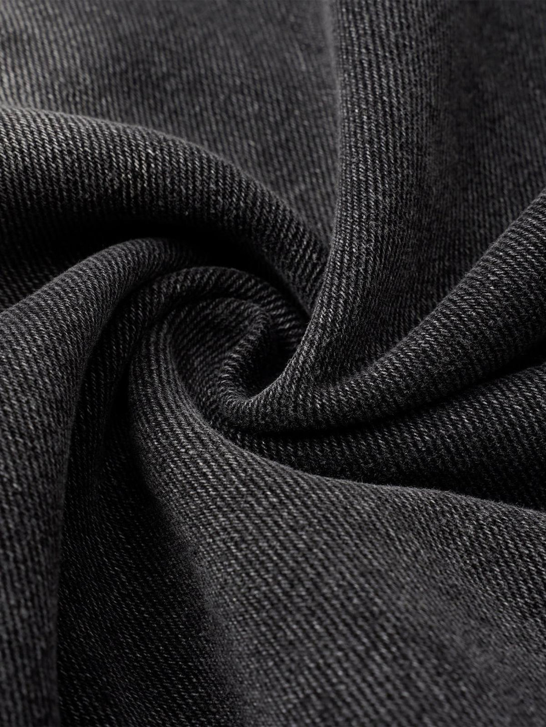 A tight crop highlighting TALISHKO's textured fabric and raw edge detail of barrel jeans.