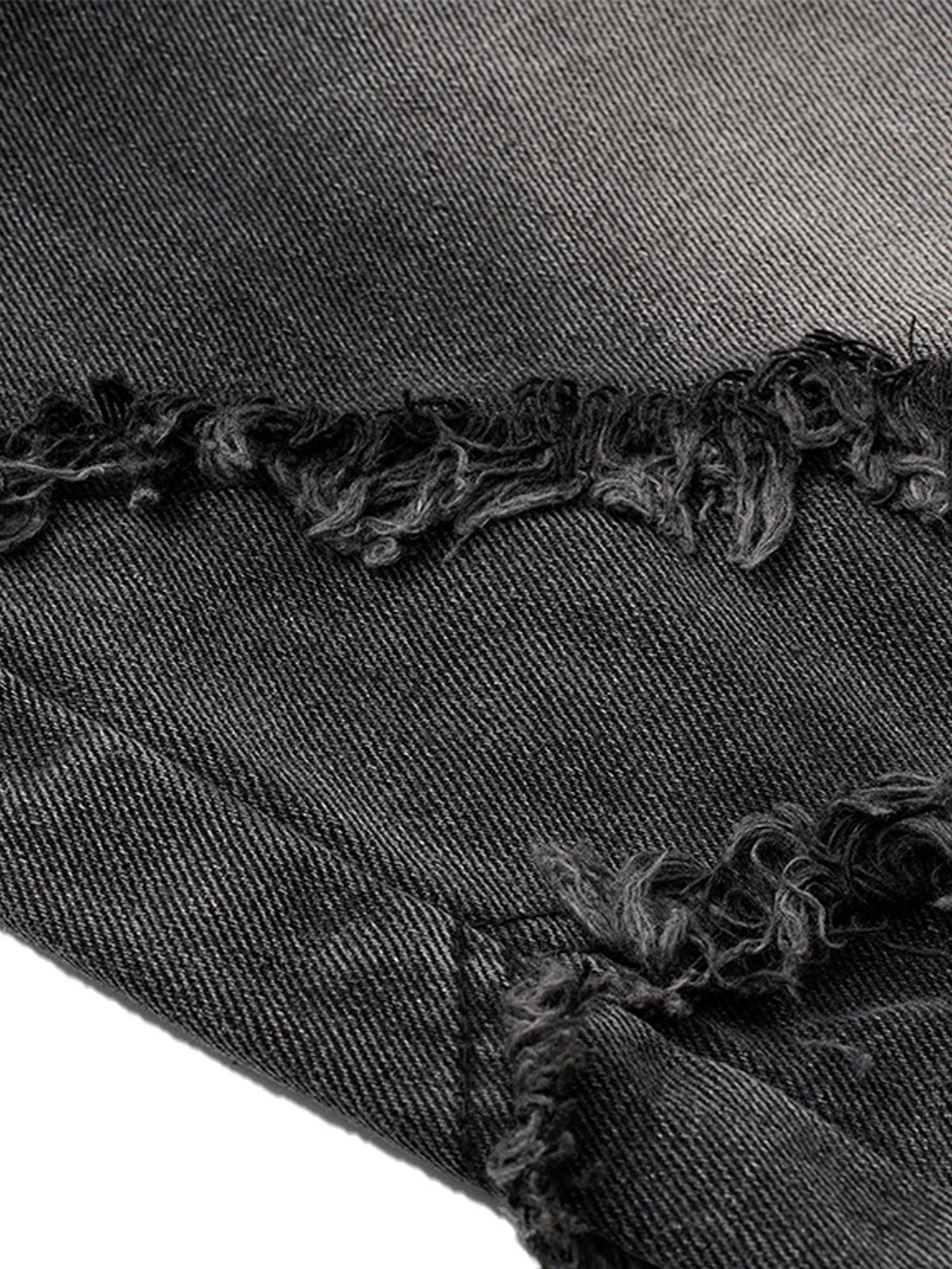 Zoomed-in texture of TALISHKO barrel jeans highlighting distressed raw edges.