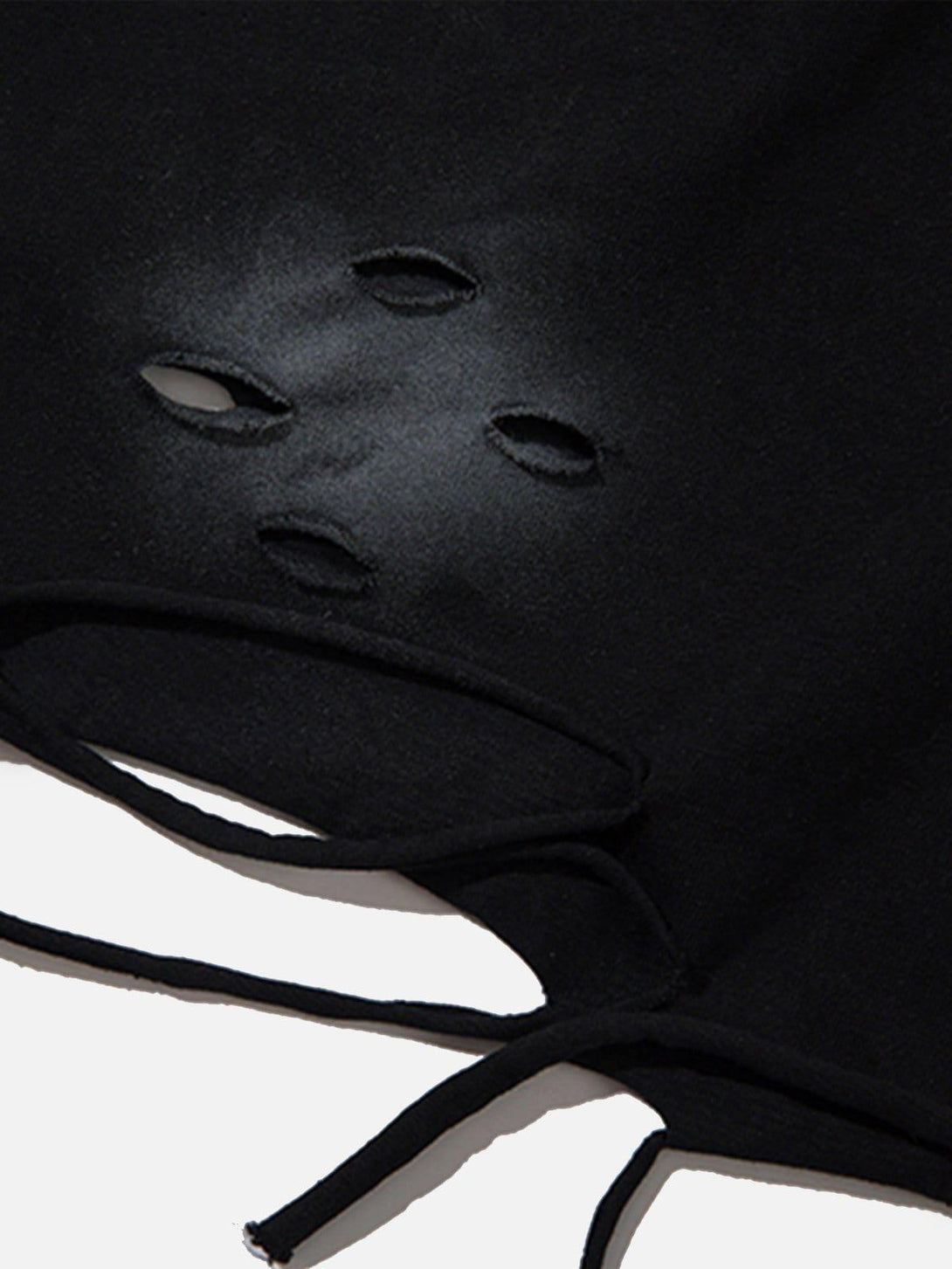A detailed view of distressed fabric on a black tee by TALISHKO, showcasing raw edge style.
