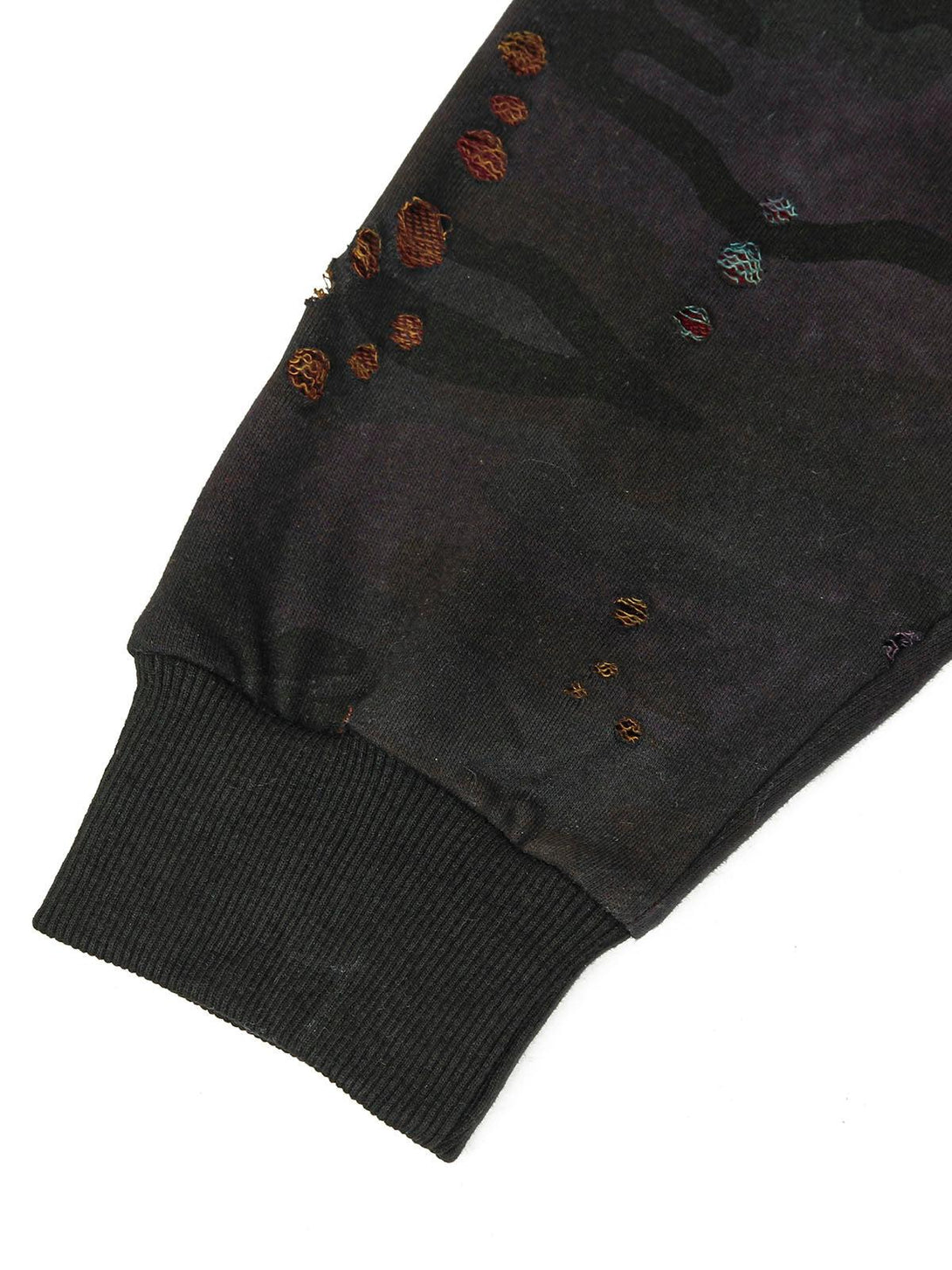 A close-up of TALISHKO's washed distressed jacket sleeve, showcasing colorful textured details.