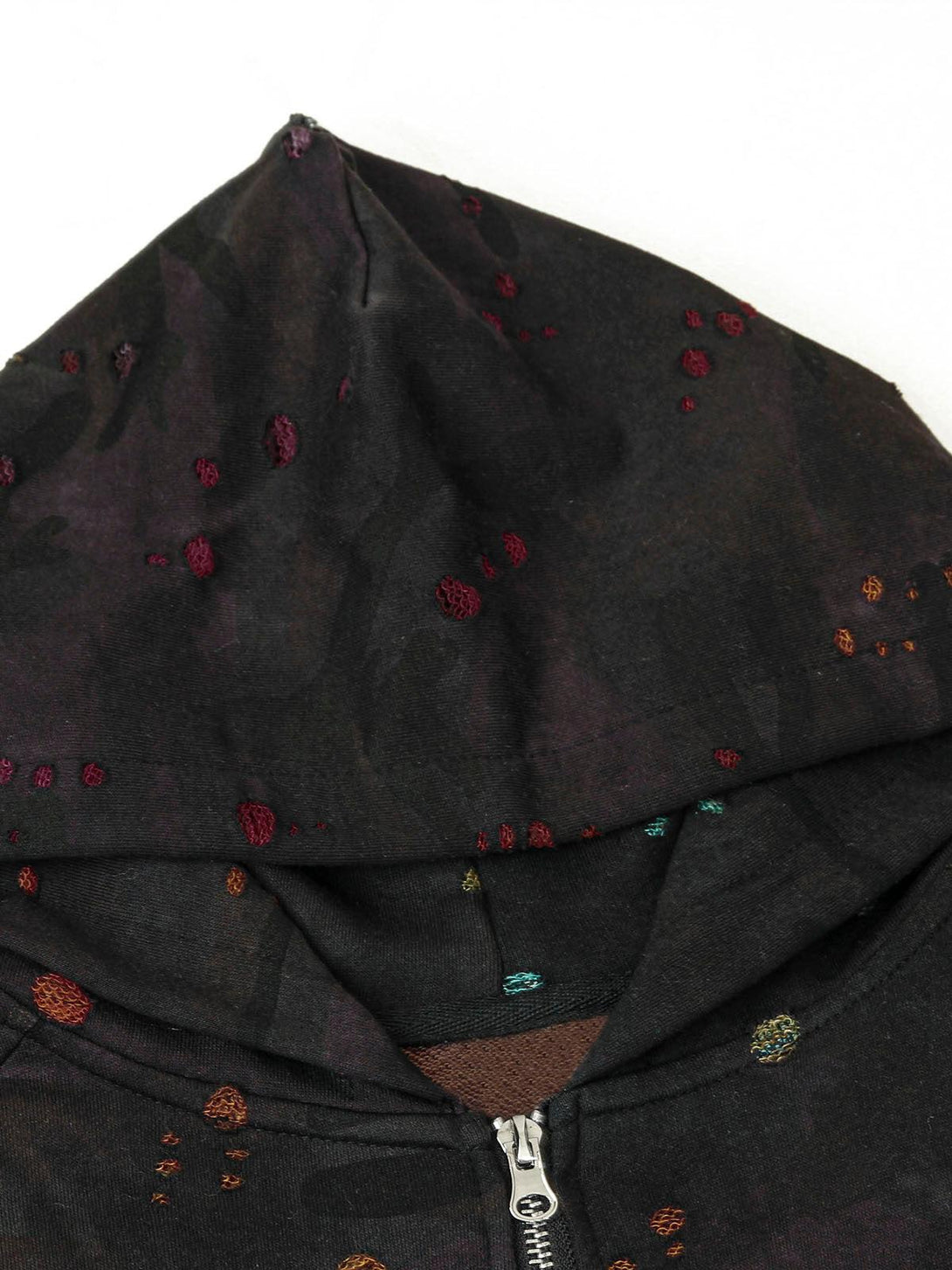 Intricate look at the washed distressed texture of TALISHKO's hooded jacket, highlighting colorful details.